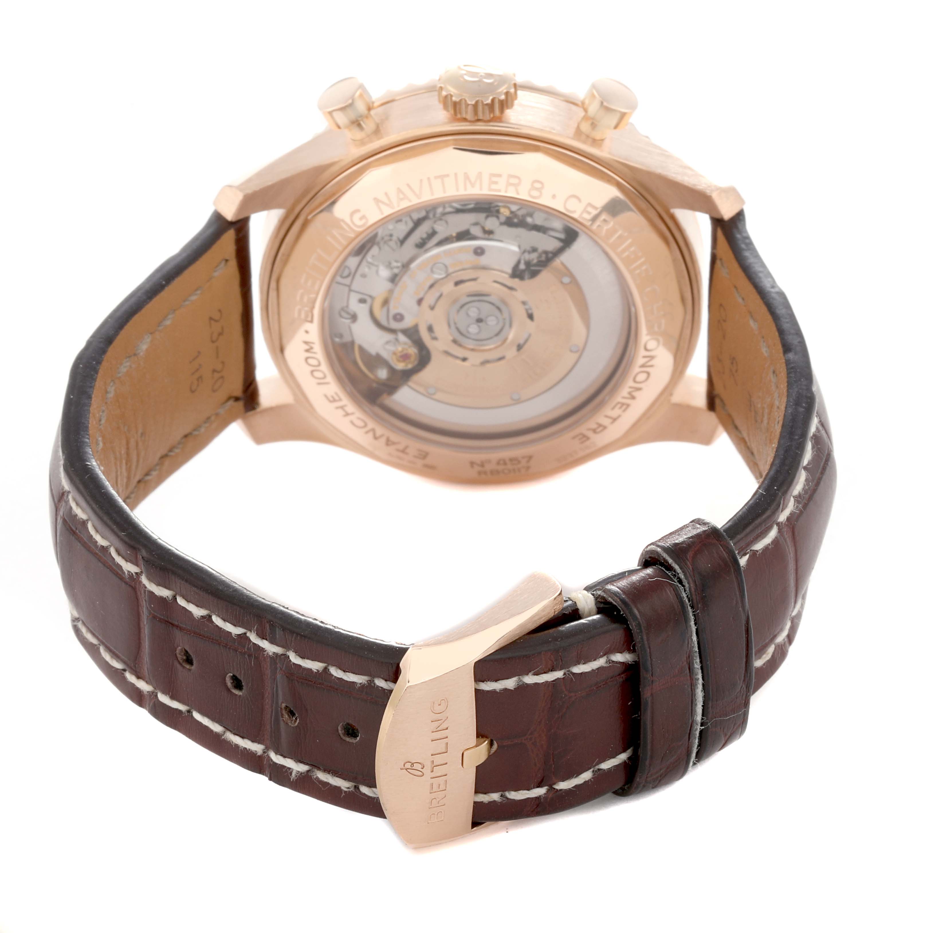 The image shows the back of a Breitling Navitimer RB0117 Men
s Rose Gold Brown Dial watch, highlighting the movement and brown leather strap with a buckle.