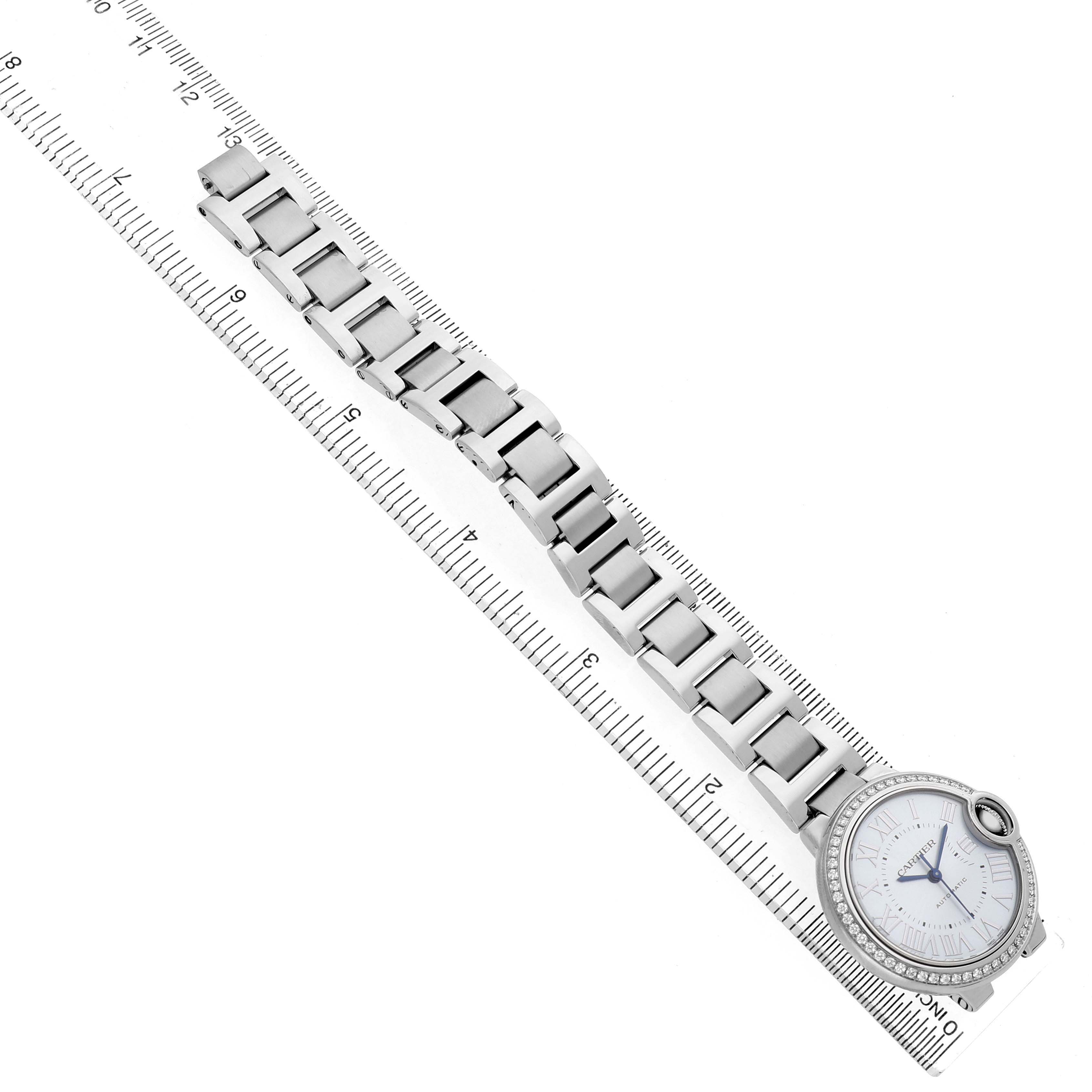 The Cartier Ballon Bleu W4BB0028 Women's Stainless Steel Blue Dial watch is shown from a top view, displaying its face and full bracelet next to a ruler.
