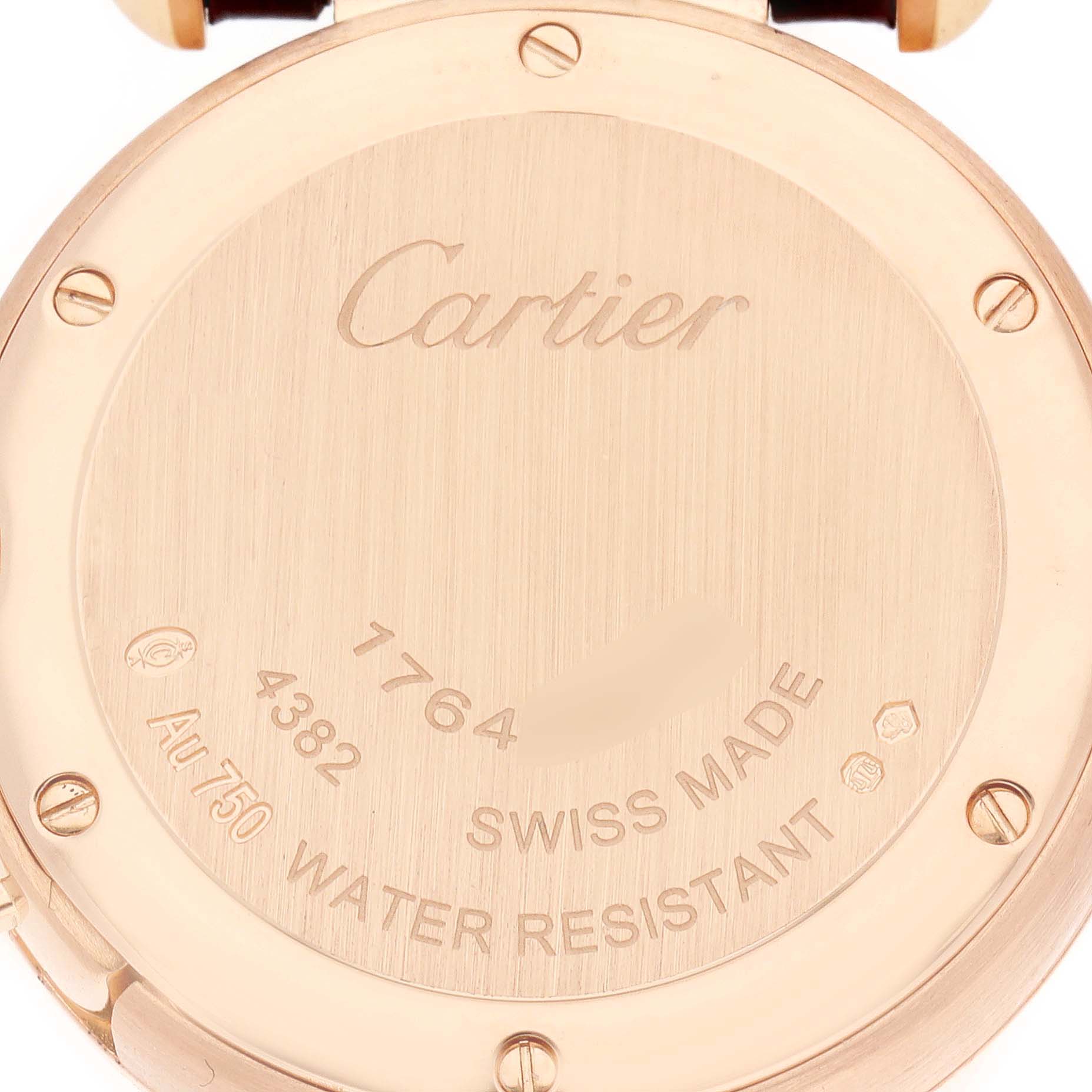 The image shows the back of a Cartier Pasha WJPA Women's Rose Gold Silver Dial watch, featuring engraved details and screws.