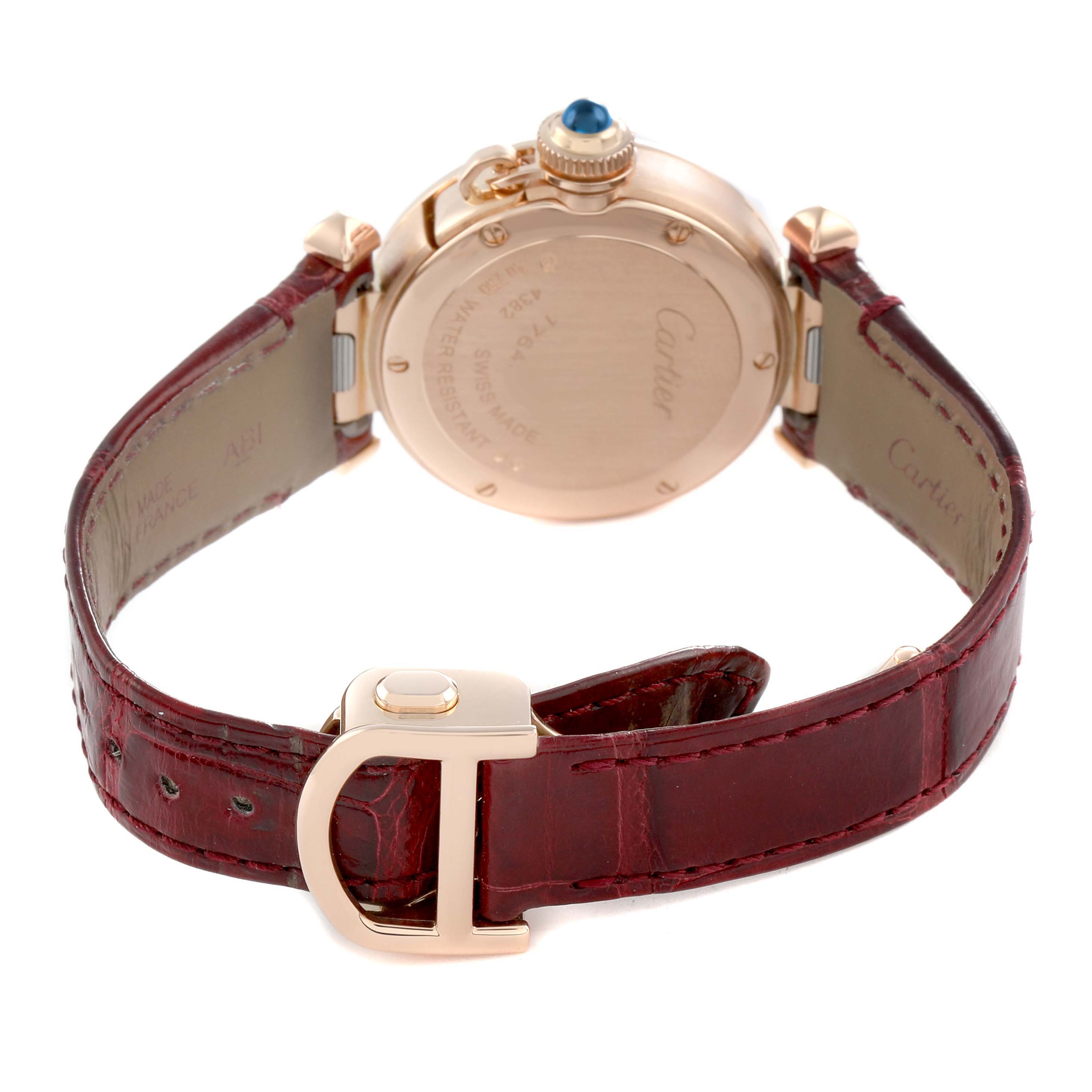 The Cartier Pasha WJPA Women's Rose Gold Silver Dial watch is shown from the back, displaying the case back, crown, and red leather strap with a deployment clasp.