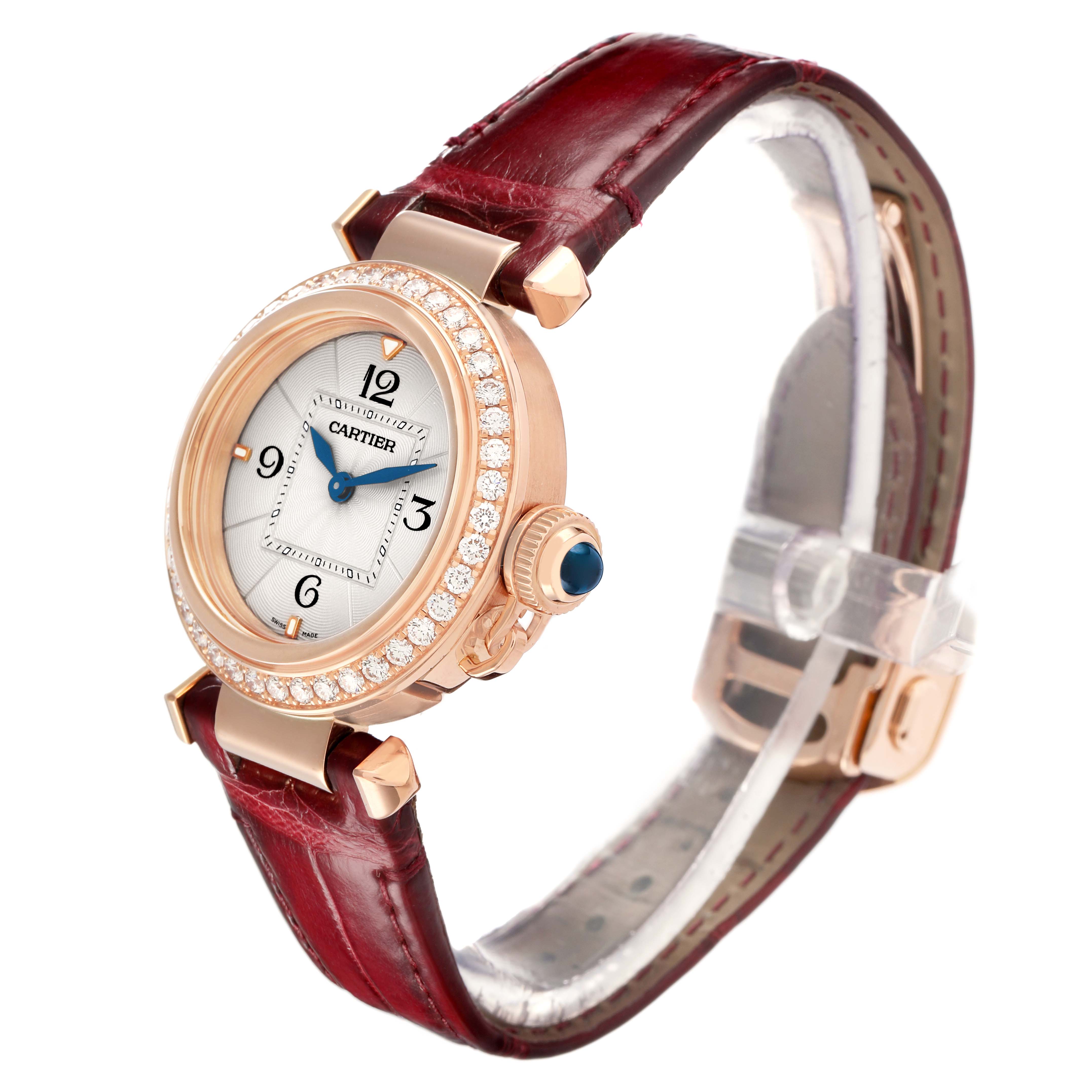 The Cartier Pasha WJPA Women's Rose Gold Silver Dial watch is shown at a slight angle, displaying its face, diamond bezel, and burgundy leather strap.