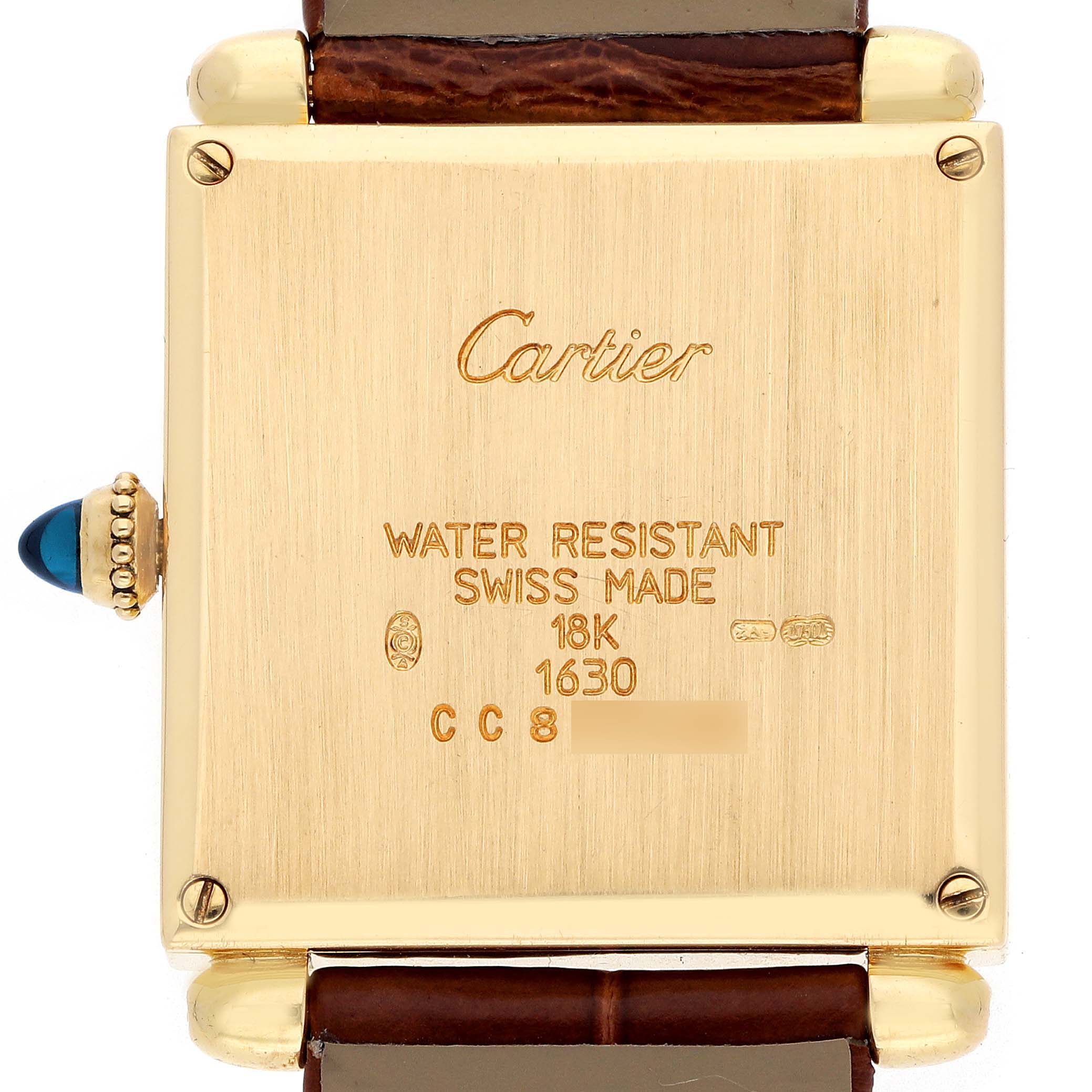The image shows the back of a Cartier Tank Obus W1512256 Women's Yellow Gold Silver Dial watch, featuring inscriptions and a glimpse of the strap and crown.