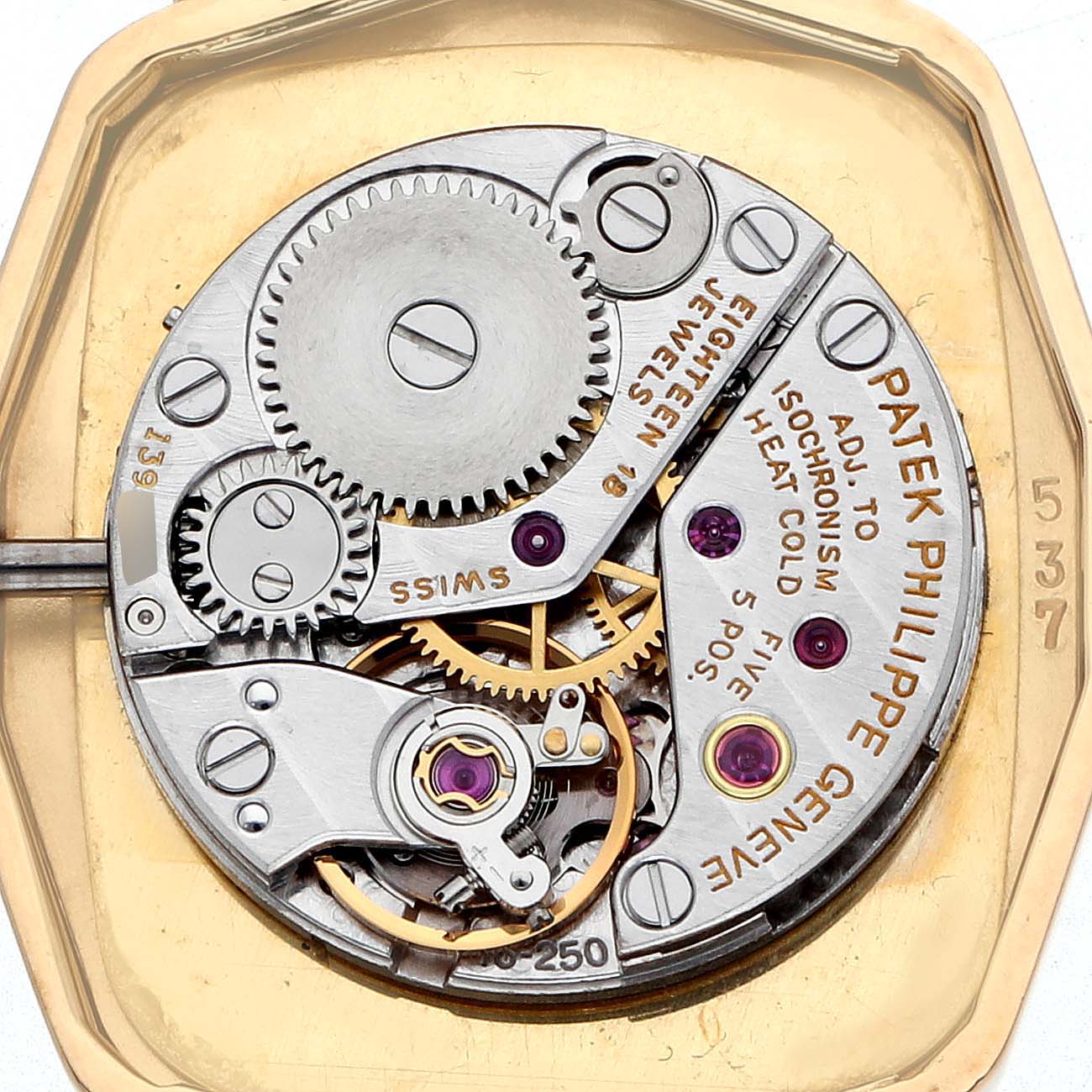 The image shows the inner movement of a Vintage Patek Philippe watch, highlighting gears and mechanical components.