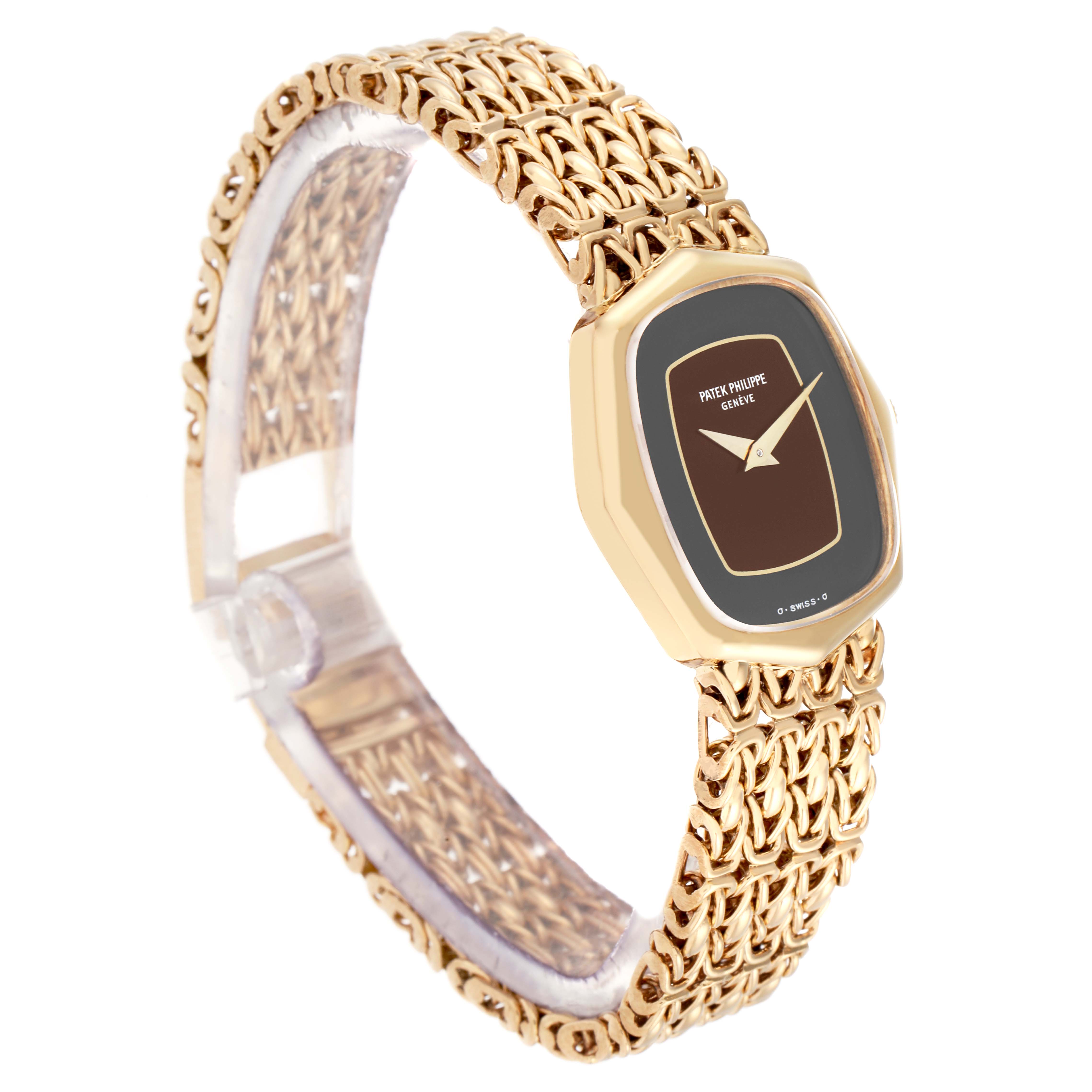 The Patek Philippe Vintage 4460J Women's Yellow Gold Black Dial model is shown at an angled view, highlighting its gold case, brown dial, and intricate gold bracelet.