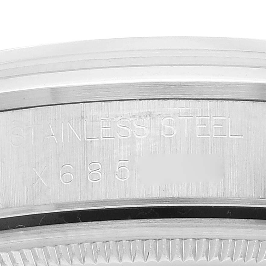 This image shows a close-up view of the Rolex Air-King 14000 Men's Stainless Steel White Dial 14000 Men's Stainless Steel White Dial stainless steel watch case with a partial engraving.