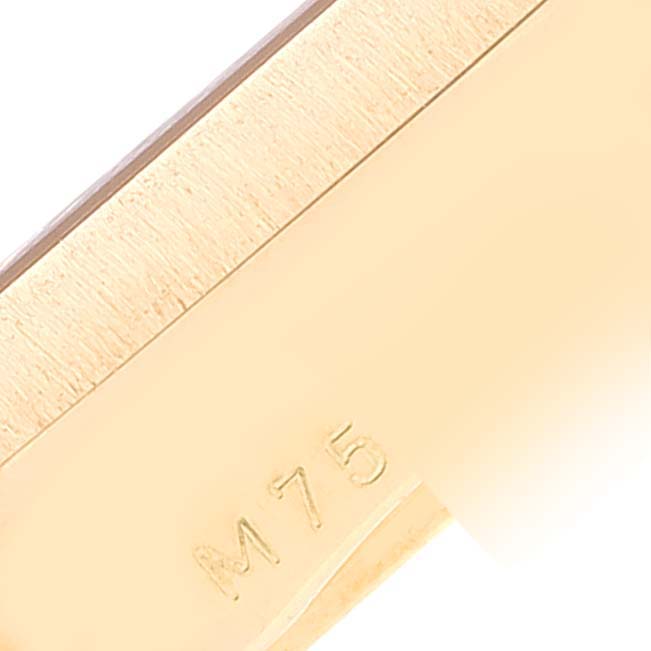 This is a close-up image of a section of the Rolex Cellini 5440/8 Men's Yellow Gold Champagne Dial 5440/8 Men's Yellow Gold Champagne Dial watch's clasp with "M 75" inscribed on it.