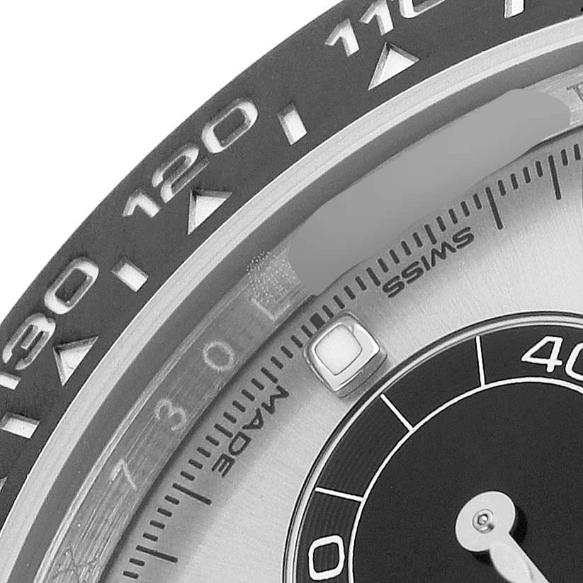 The image shows a close-up of the bezel and part of the dial of a Rolex Daytona 116519LN Men's White Gold Silver Dial watch.