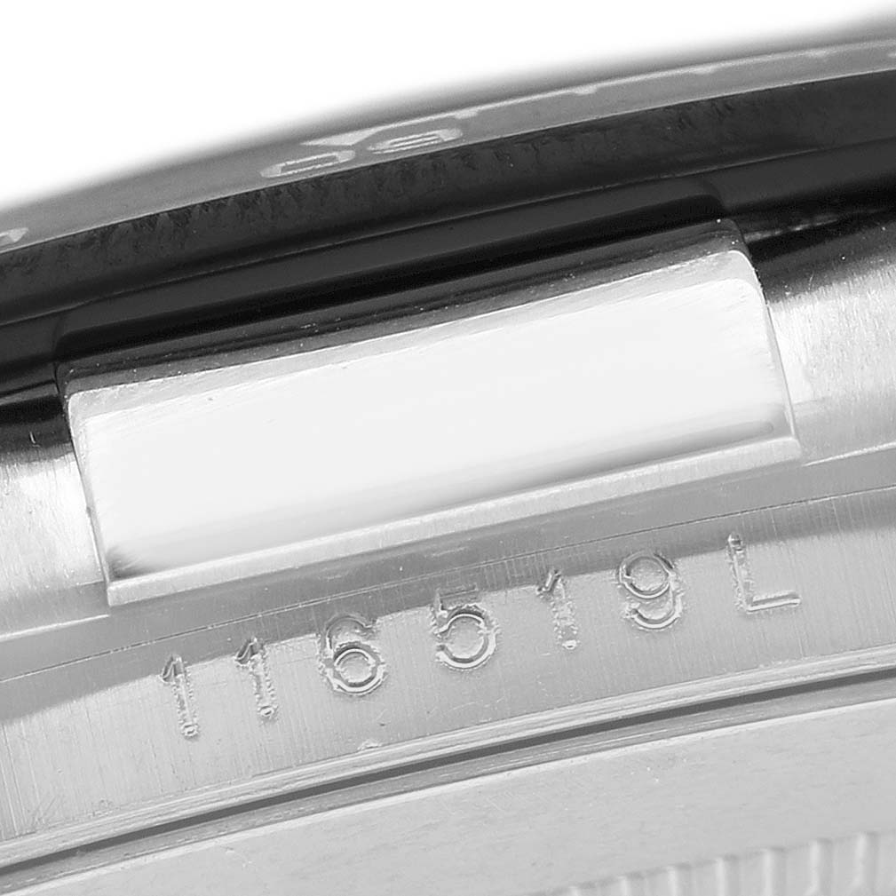The image shows a close-up of the side of a Rolex Daytona 116519LN Men's White Gold Silver Dial, focusing on the engraved serial number and part of the bezel.