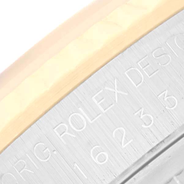 This image shows a close-up of the side of the Rolex Datejust 16233 Men's Steel and Gold (two tone) Blue Dial 16233 Men's Steel and Gold (two tone) Blue Dial watch, featuring part of the bezel and engraved serial numbers.