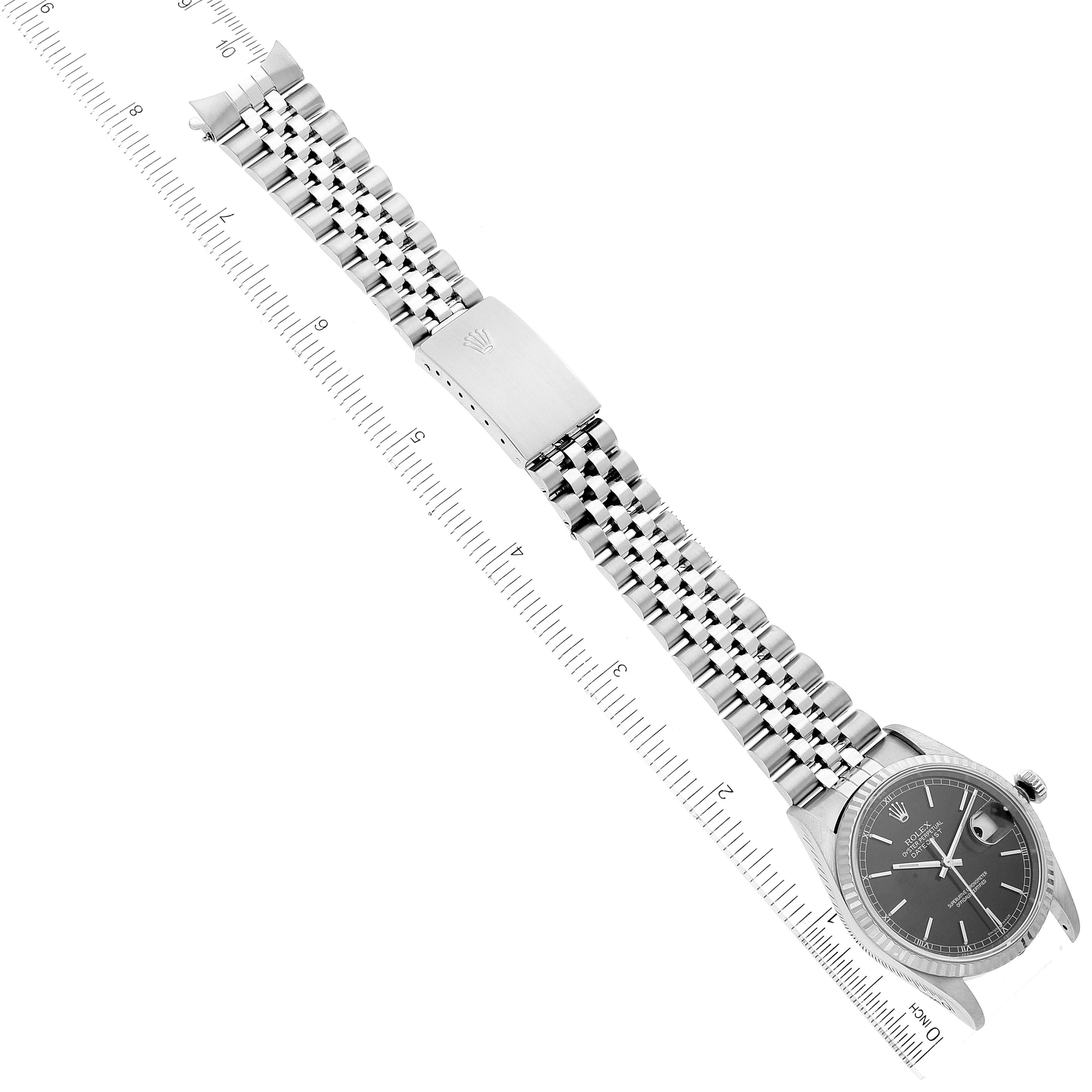 The image shows a top-down view of a Rolex Datejust 16234 Men's Stainless Steel Black Dial 16234 Men's Stainless Steel Black Dial watch with a jubilee bracelet, a ruler is placed beneath for measurement.