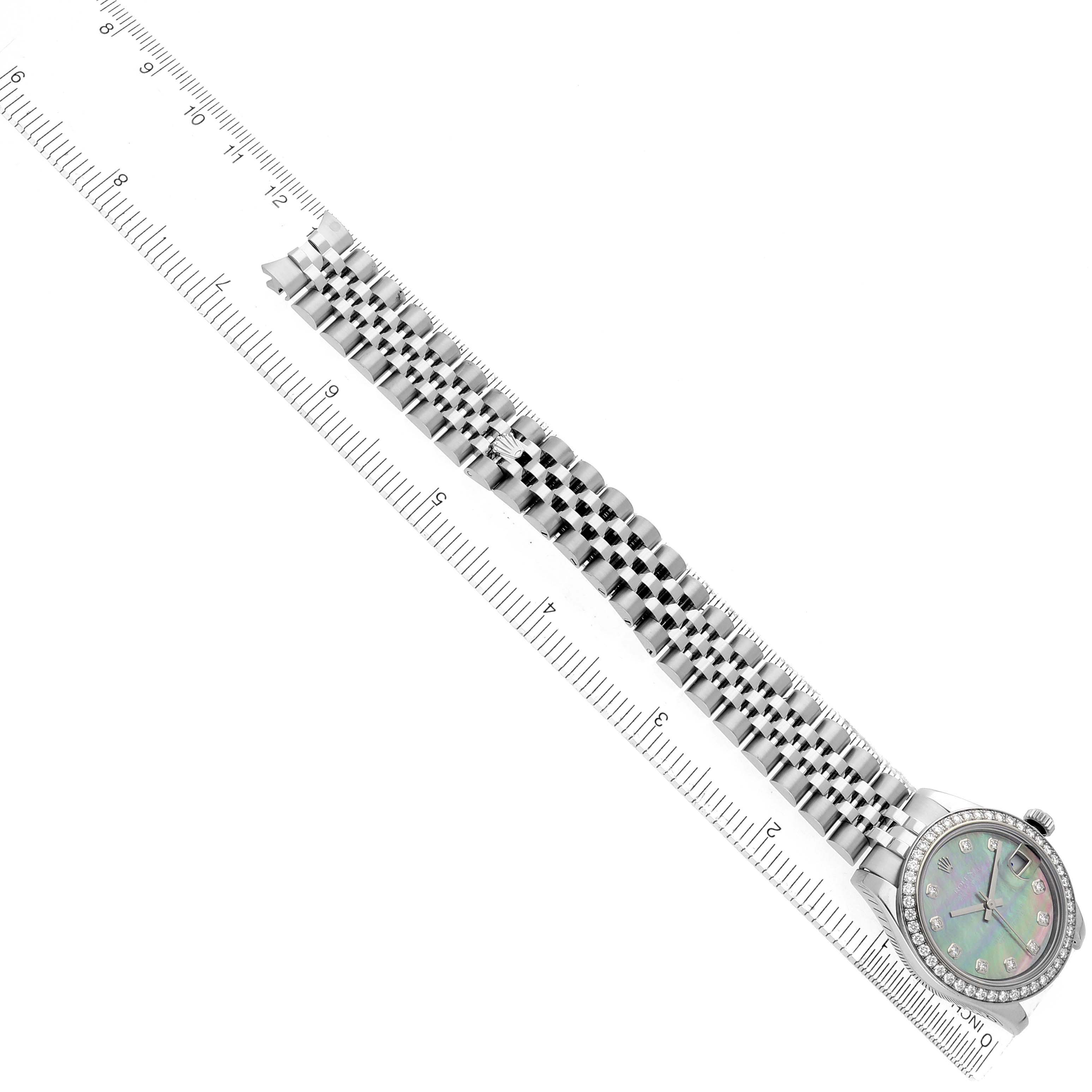 The Rolex Datejust 178384 Women
s Stainless Steel Mother of Pearl Dial watch is shown from a top angle, displaying the full bracelet and face next to a ruler for scale.