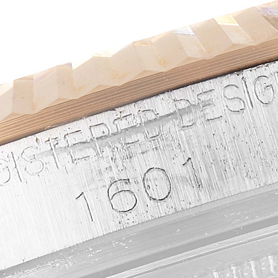 This close-up image shows the bezel and engraved serial number of a Rolex Vintage Collection 1601 Men's Steel and Gold (two tone) Black Dial 1601 Men's Steel and Gold (two tone) Black Dial model 1601.