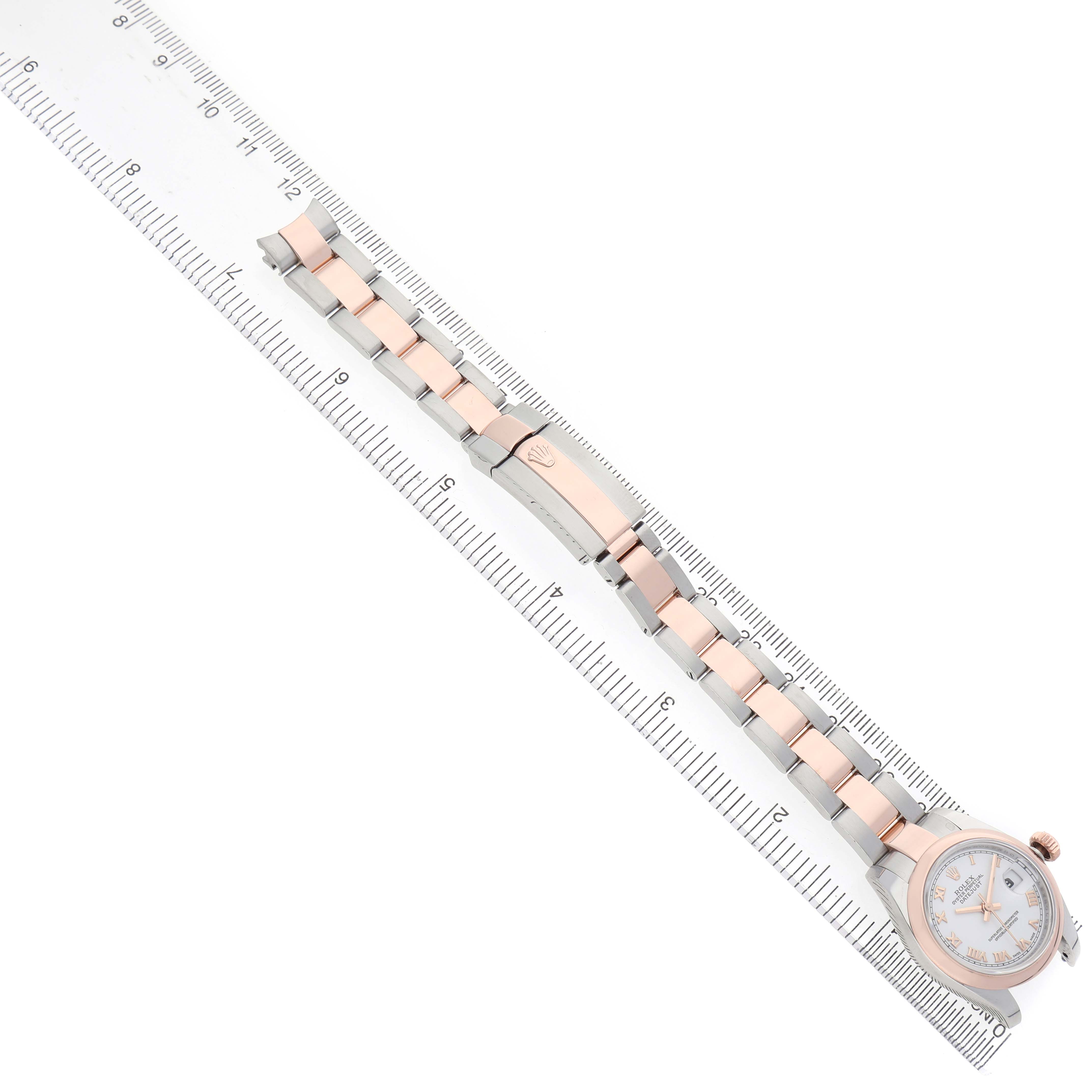 The image shows a Rolex Datejust 179161 Women's Stainless Steel White Dial watch laid flat with its bracelet extended alongside a ruler.