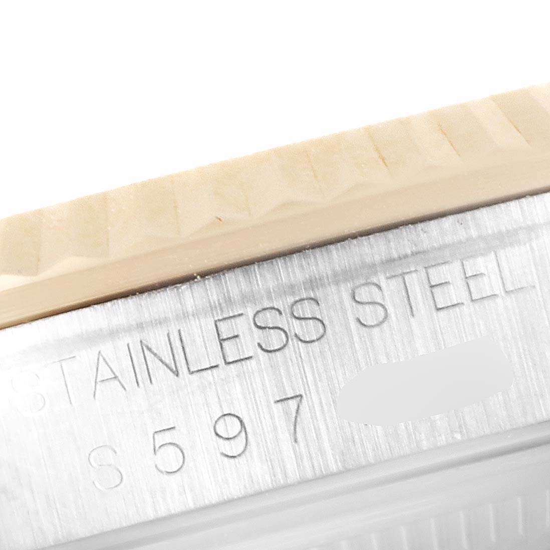 This close-up image shows the fluted bezel and part of the case with serial number engraving of a Rolex Datejust 16233 Men's Steel and Gold (two tone) Champagne Dial 16233 Men's Steel and Gold (two tone) Champagne Dial watch.