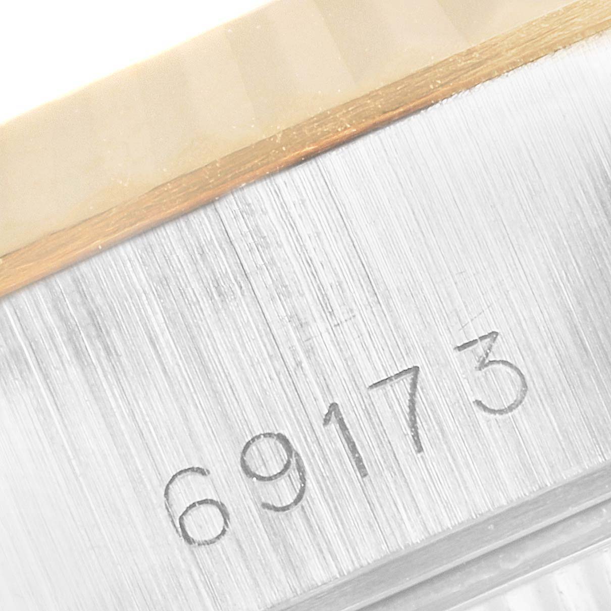 The image shows a close-up angle of the Rolex Datejust 69173 Women
s Steel and Gold (two tone) Silver Dial 69173 Women
s Steel and Gold (two tone) Silver Dial model, focusing on the engraved model number "69173" on a brushed metal part of the watch.