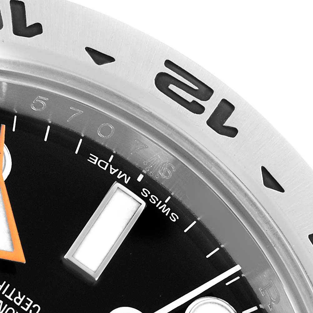 The image shows a close-up angle of a Rolex Explorer 216570 Men
s Stainless Steel Black Dial watch, focusing on the bezel, part of the dial, and the minute hand.