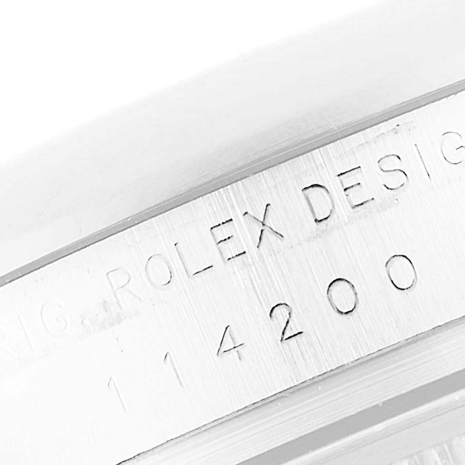 This image shows a close-up of the serial number engraving on a Rolex Oyster Perpetual 114200 Men's Stainless Steel Green Dial 114200 Men's Stainless Steel Green Dial watch.