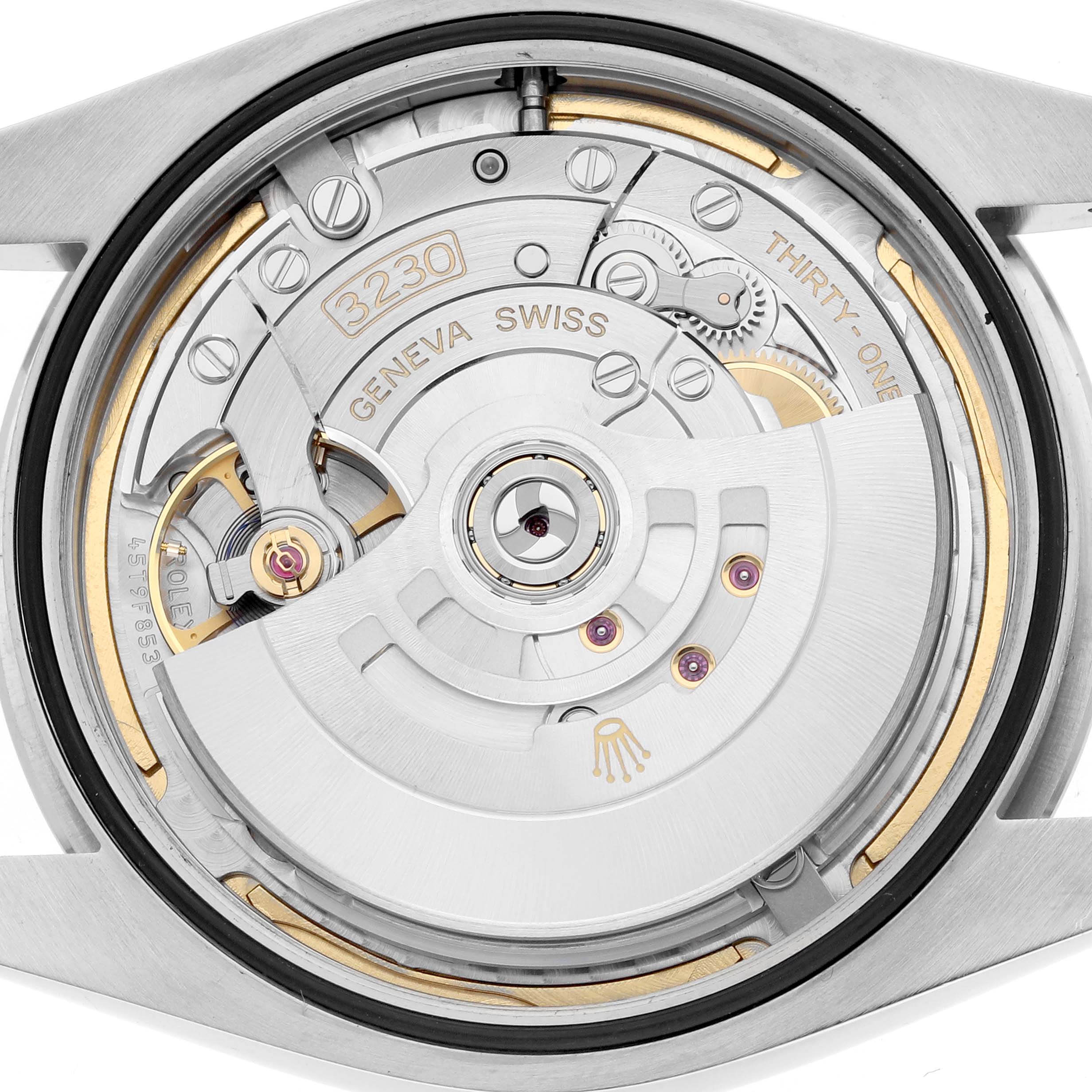 The image shows the movement of a Rolex Oyster Perpetual 124300 Men
s Stainless Steel Blue Dial watch from a rear angle, highlighting the rotor and internal mechanisms.