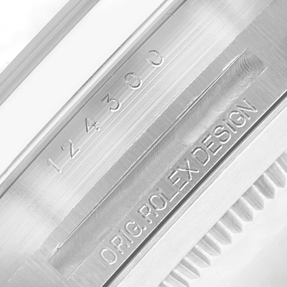 The image shows a close-up of the case side and serial engraving of a Rolex Oyster Perpetual 124300 Men
s Stainless Steel Blue Dial watch.