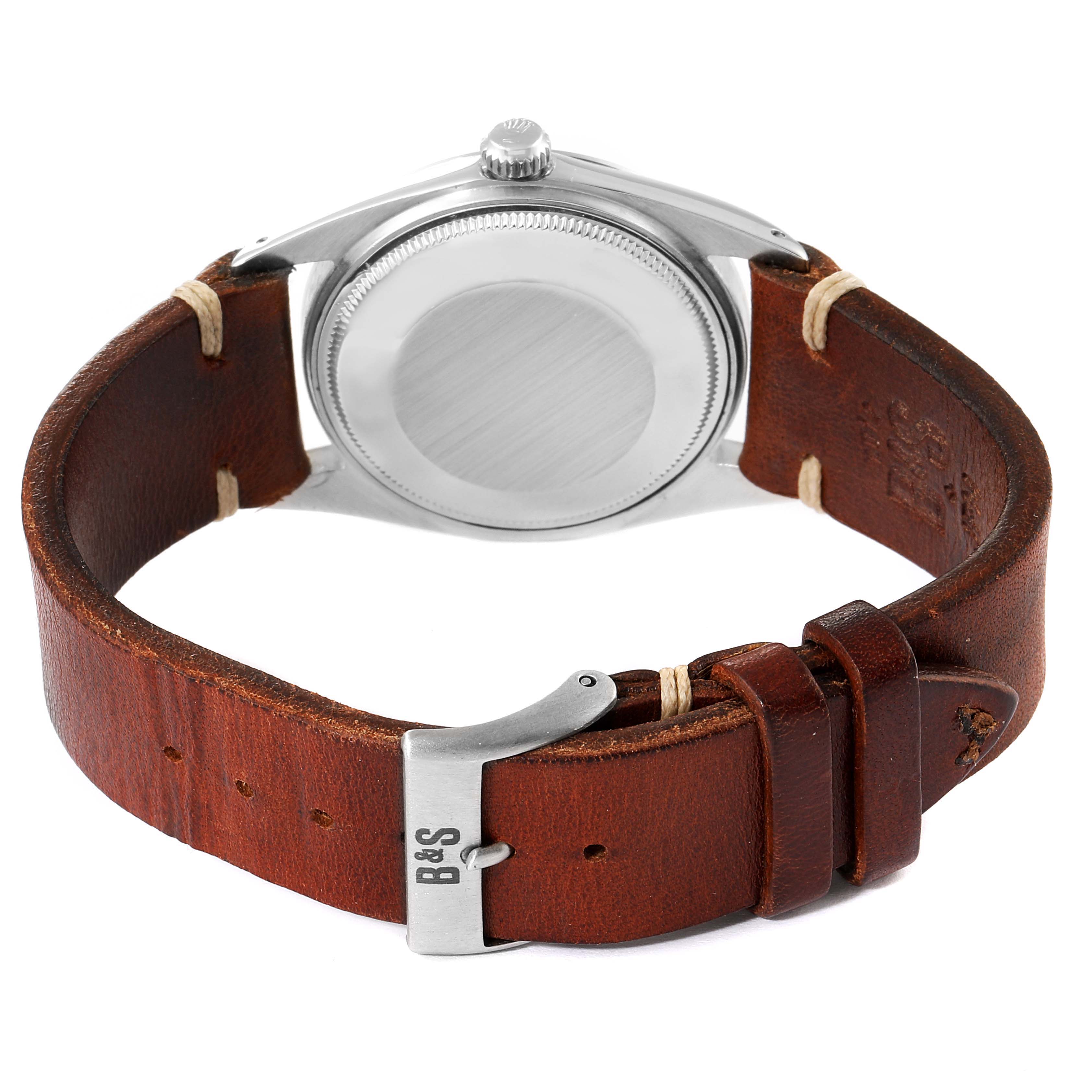 The image shows the back of the Rolex Vintage Collection 1018 Men's Stainless Steel Silver Dial 1018 Men's Stainless Steel Silver Dial watch, focusing on its case back and brown leather strap with buckle.