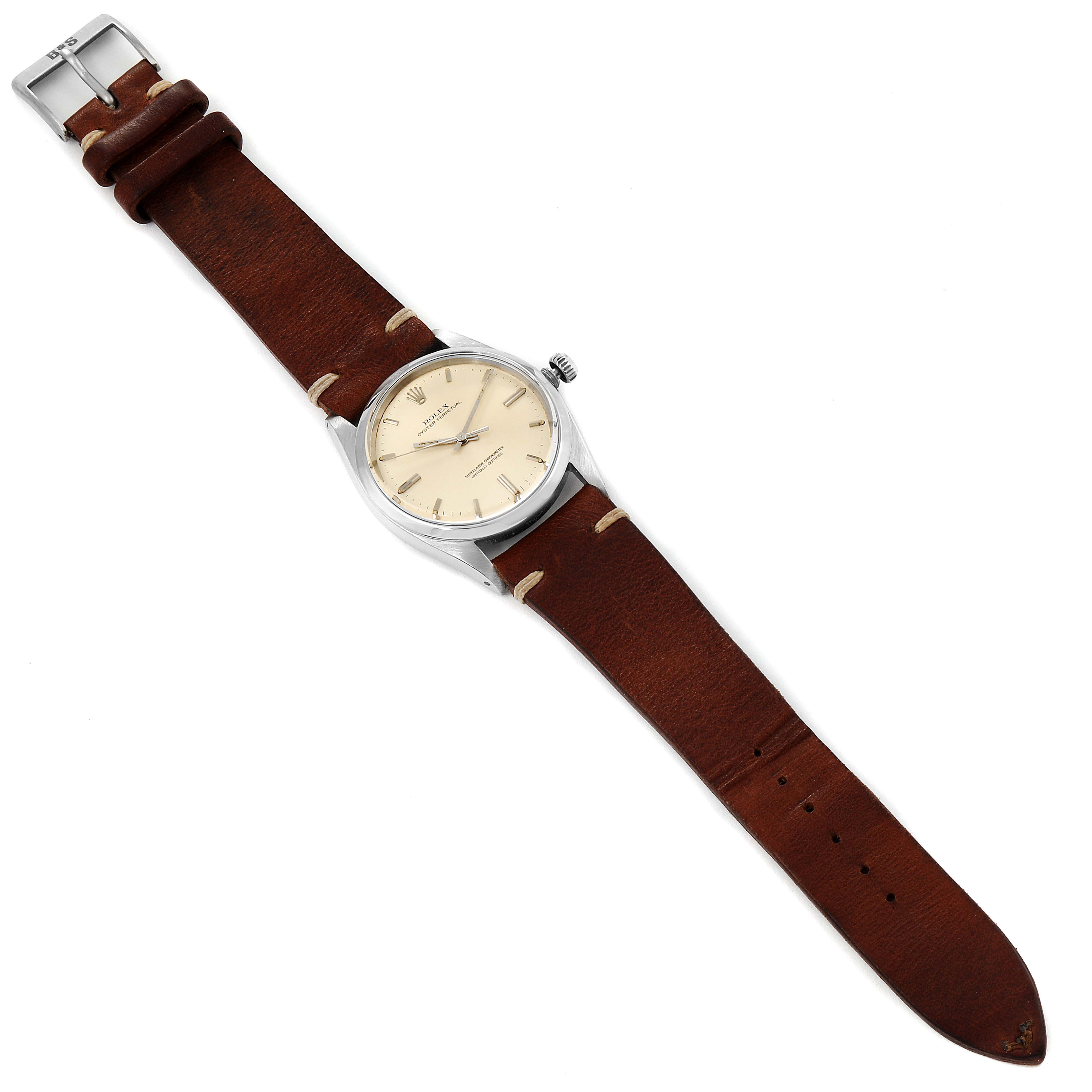 The image shows a Rolex Vintage Collection 1018 Men's Stainless Steel Silver Dial 1018 Men's Stainless Steel Silver Dial model watch, featuring a leather strap and a round, beige dial, viewed from a top-down angle.