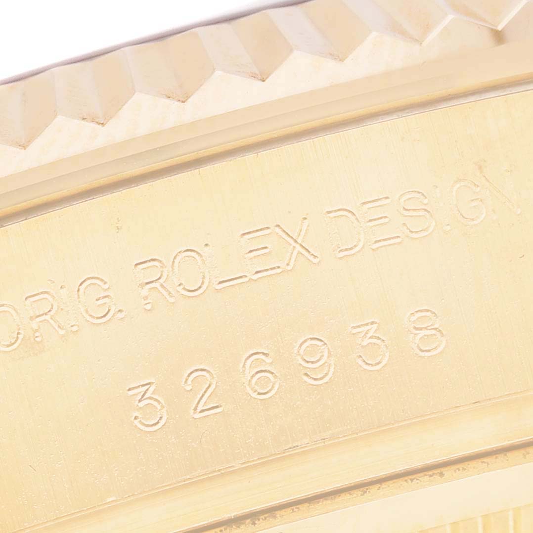 The image shows a close-up of the engraved case edge of the Rolex Sky-Dweller 326938 Men's Yellow Gold Silver Dial, highlighting the model number and brand name.