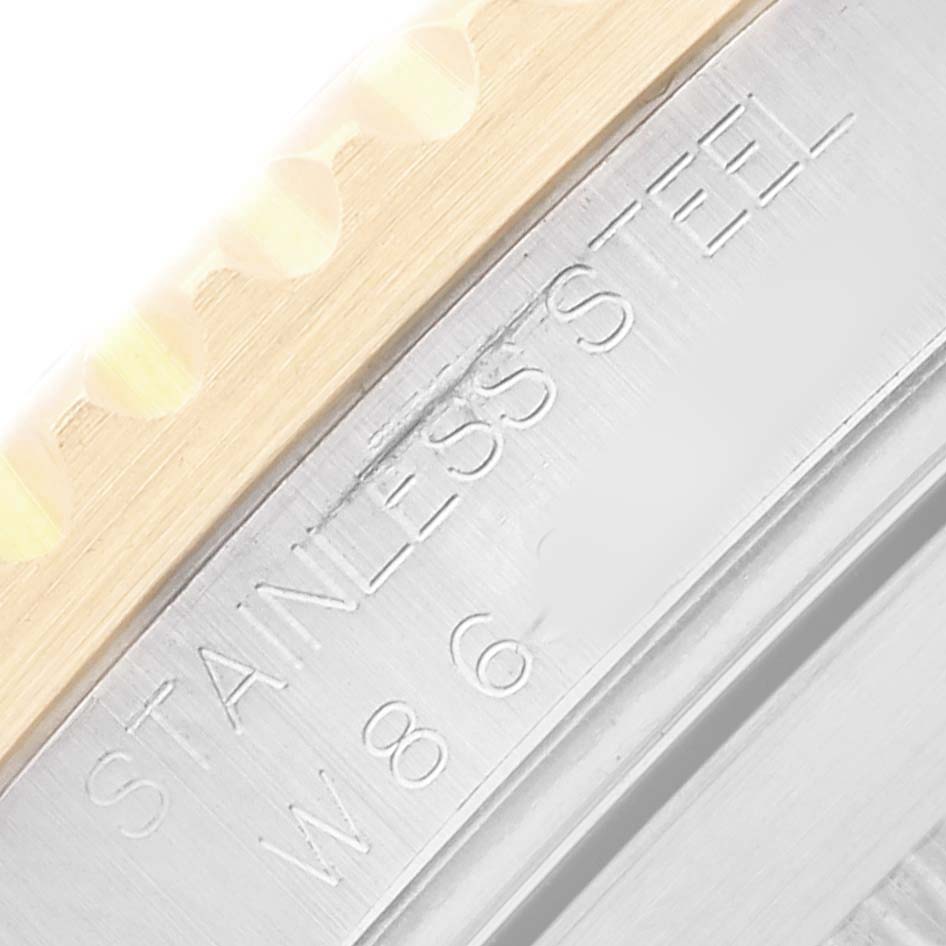 The image shows a close-up of the Rolex Submariner 16613 Men
s Steel and Gold (two tone) Black Dial
s bezel edge with "STAINLESS STEEL" engraving.