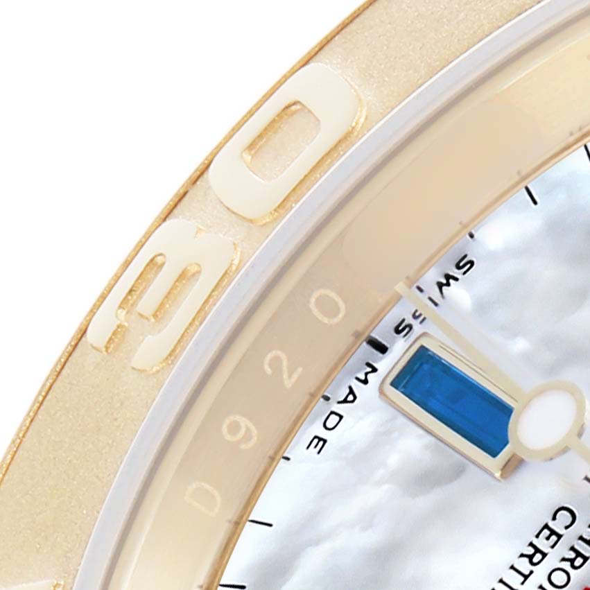 The image shows a close-up of the bezel and part of the dial of a Rolex Yacht-Master 16628B Men
s Yellow Gold Mother of Pearl Dial watch, highlighting numbers and a blue accent.
