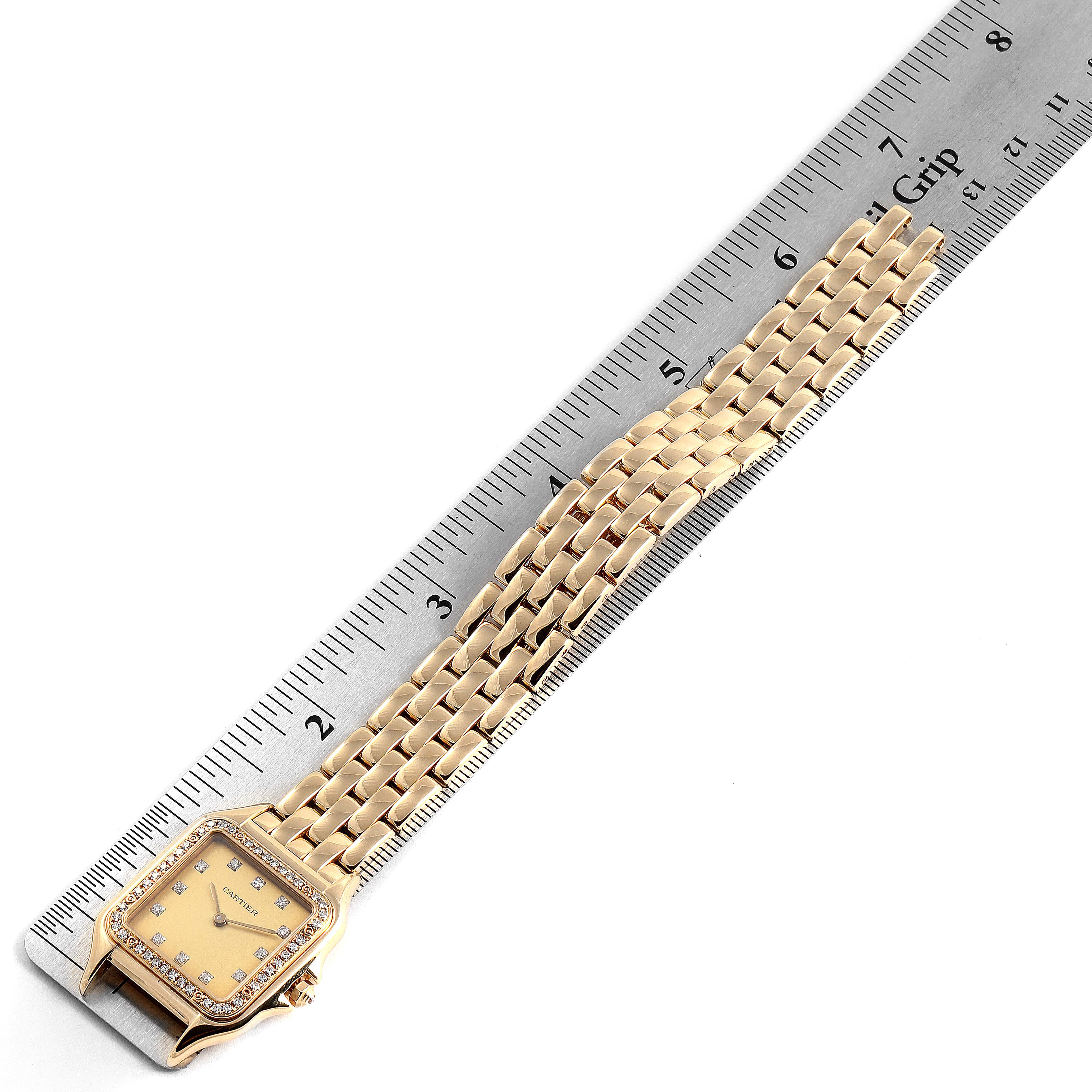 The image shows a Cartier Panthere 883969 Women's Yellow Gold Champagne Dial 883969 Women's Yellow Gold Champagne Dial model watch laid flat next to a ruler, highlighting its bracelet and face.