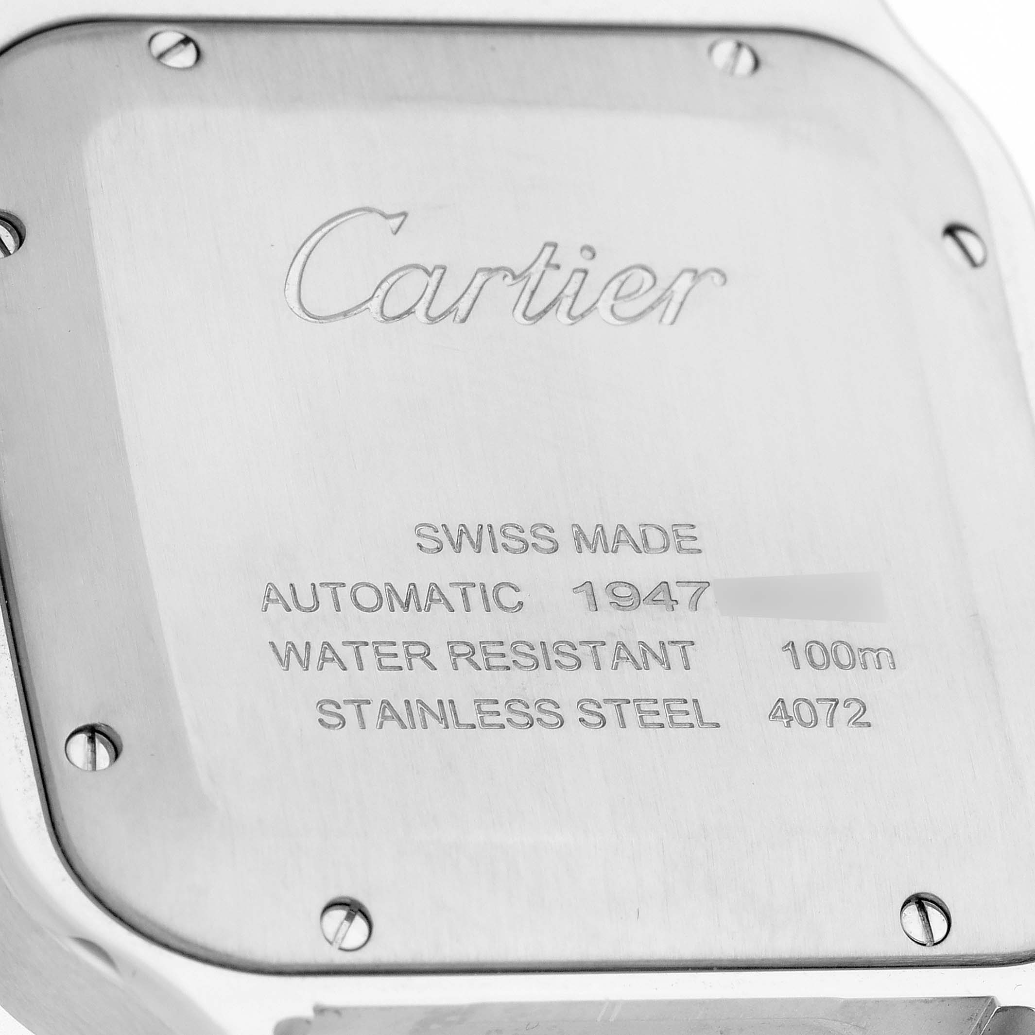 The image shows the back case of a Cartier Santos WSSA0047 Men's Stainless Steel Silver Dial WSSA0047 Men's Stainless Steel Silver Dial watch at a close-up angle, displaying the brand name, specifications, and securing screws.