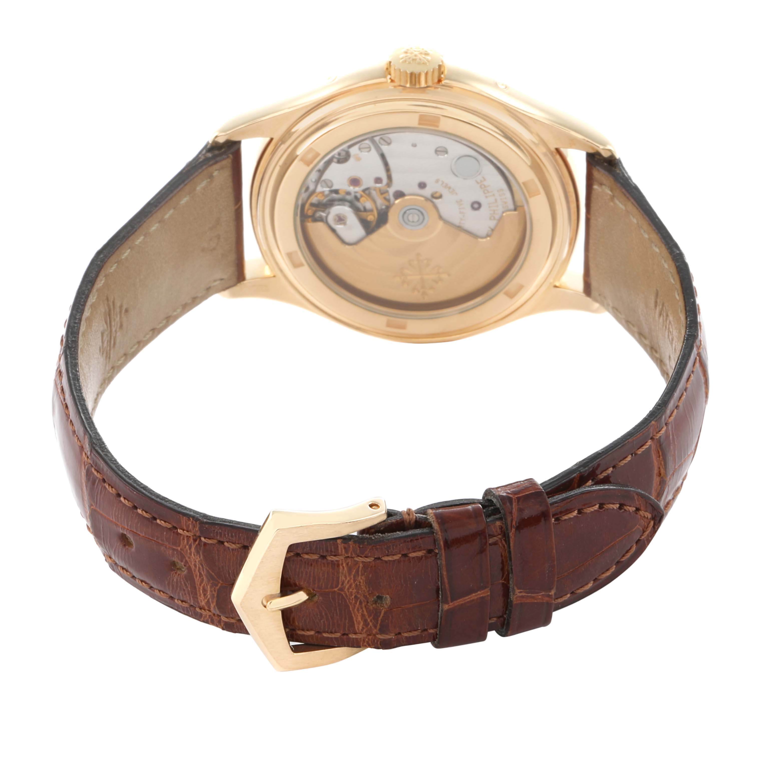 The Patek Philippe Complications 5035J Men
s Yellow Gold White Dial watch is shown from the back, highlighting its transparent case back and leather strap.