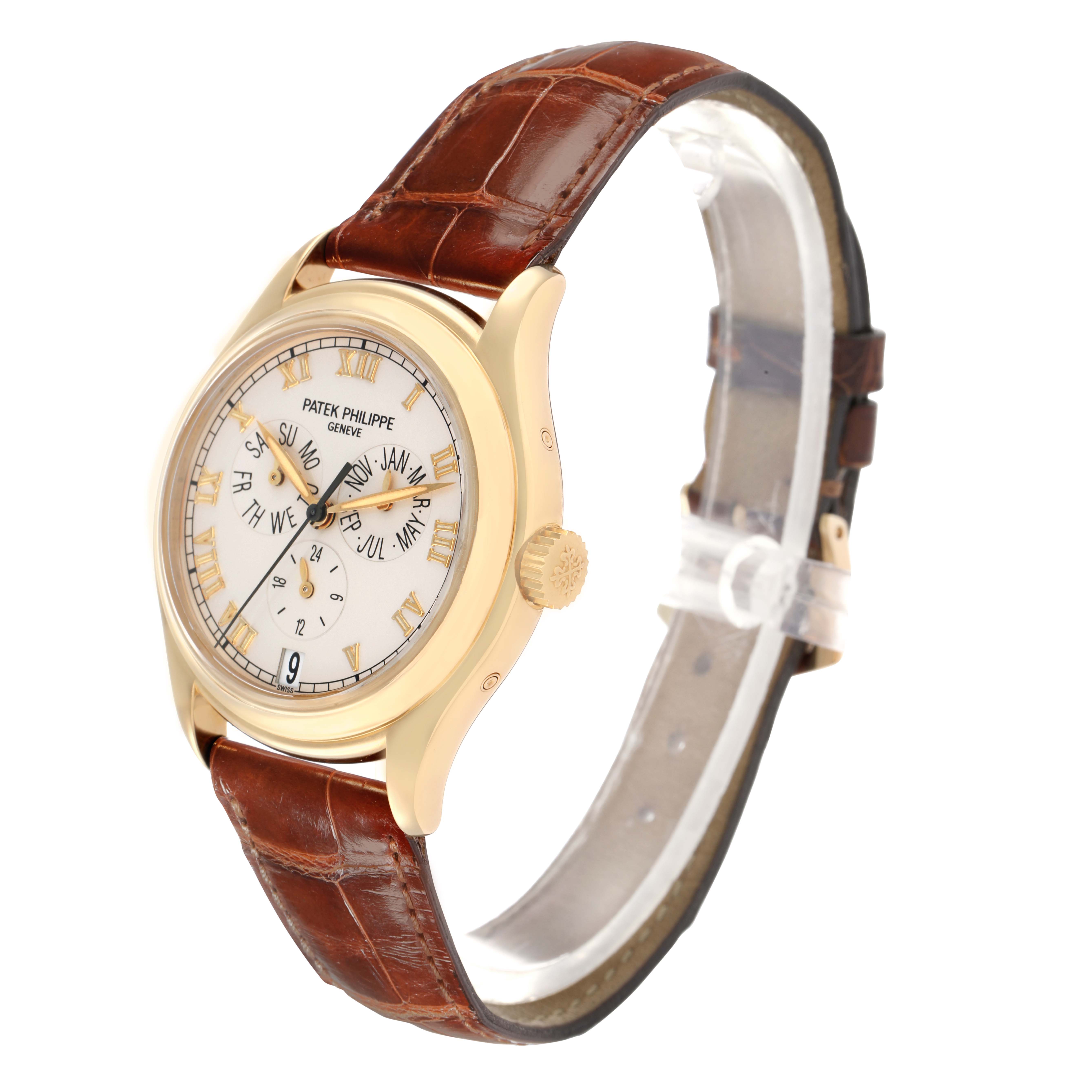 The Patek Philippe Complications 5035J Men
s Yellow Gold White Dial watch is shown from a three-quarter view, highlighting the face, crown, and brown leather strap.