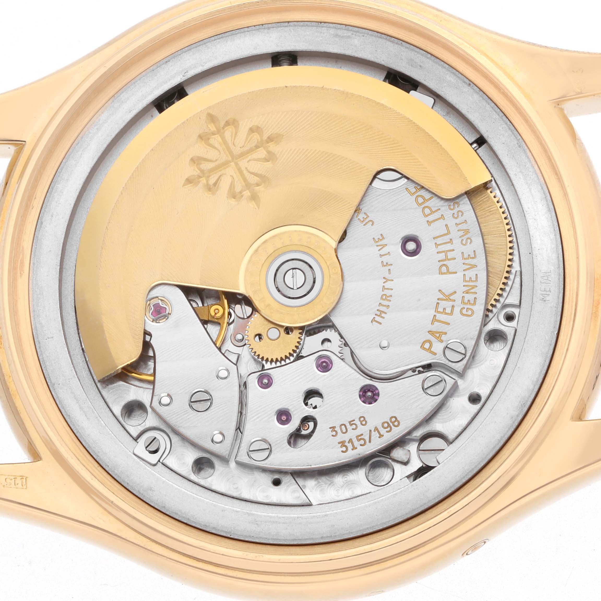 The image shows the movement of a Patek Philippe Complications 5035J Men
s Yellow Gold White Dial watch from a rear angle, showcasing its intricate gears and rotor.