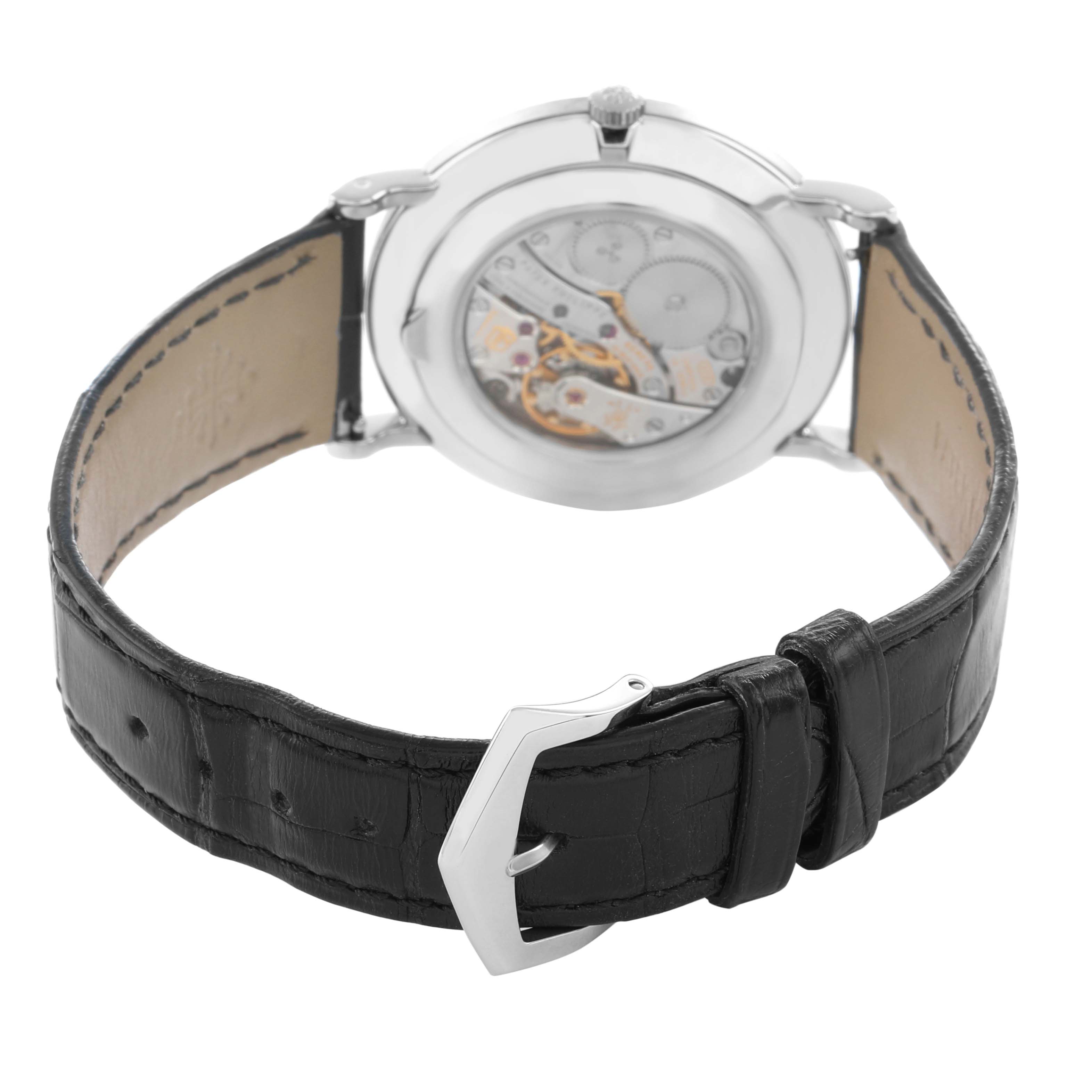 The image shows the back view of a Patek Philippe Calatrava 5119G-001 Men
s White Gold White Dial watch, highlighting its mechanical movement and black leather strap.
