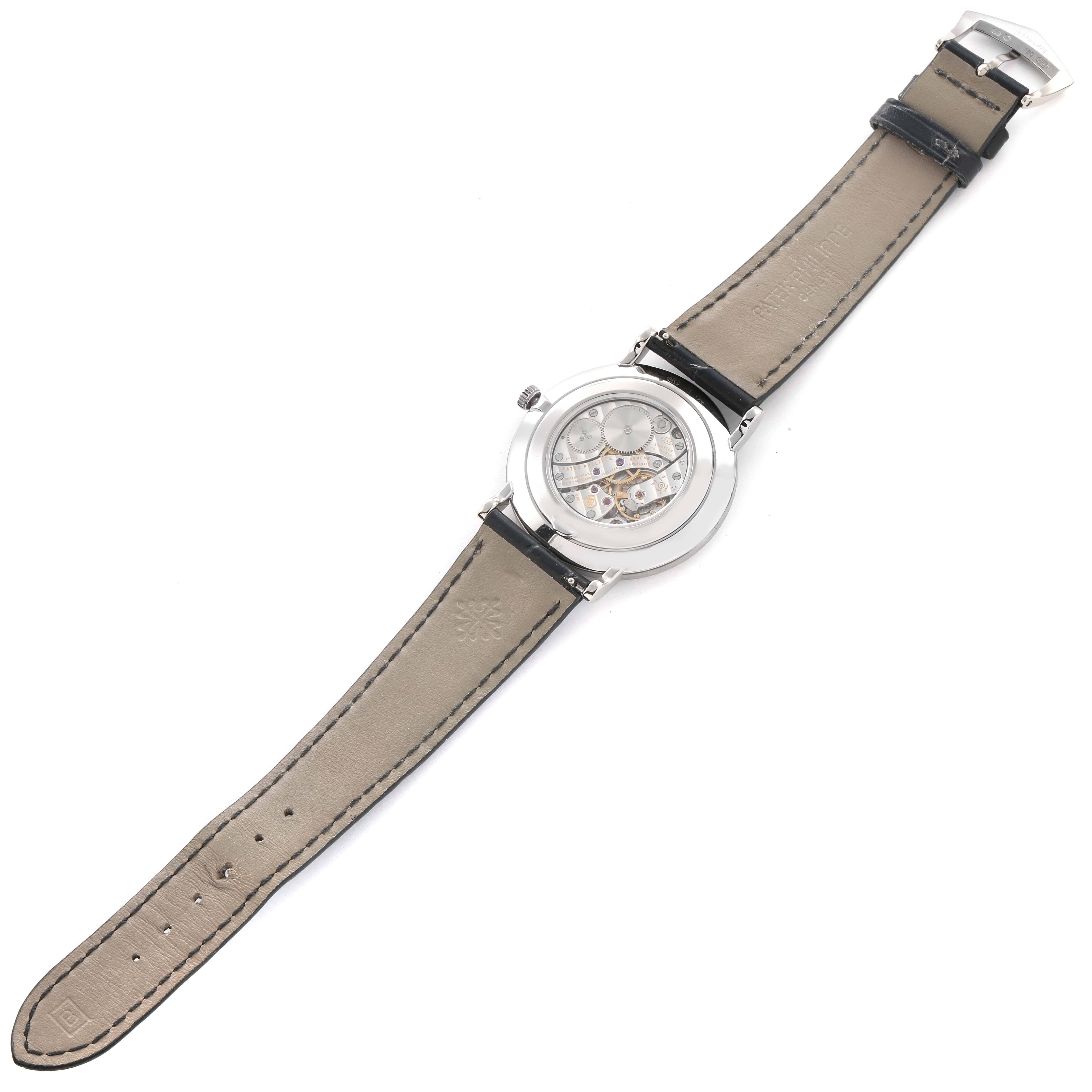 The Patek Philippe Calatrava 5119G-001 Men
s White Gold White Dial watch is shown from the back, displaying the movement and the leather strap.