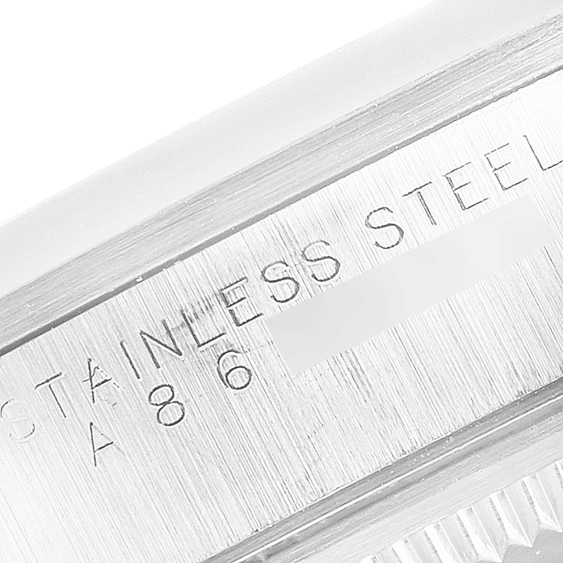 The image shows a close-up of the side of a Rolex Date 15200 Men's Stainless Steel Blue Dial 15200 Men's Stainless Steel Blue Dial model watch, focusing on the engraved "STAINLESS STEEL" text.