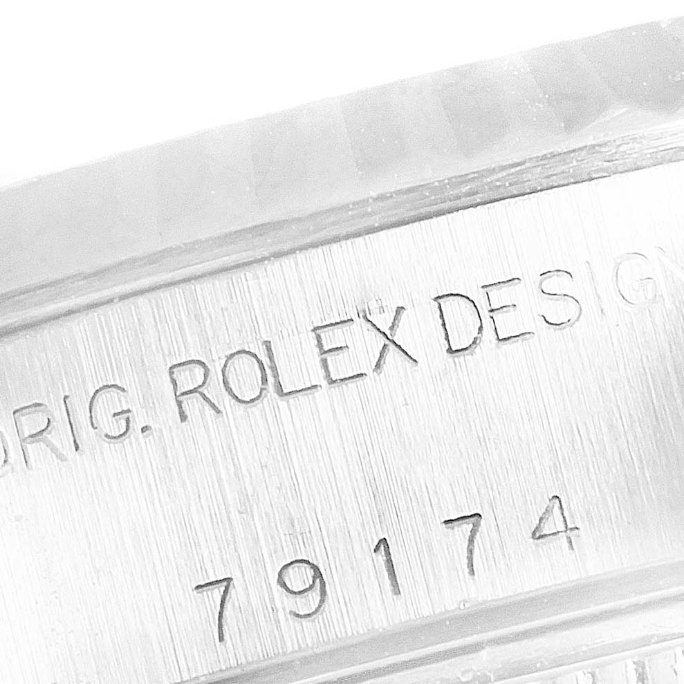 The image shows a close-up of the engraving on the side of the bezel of a Rolex Datejust 79174 Women's Stainless Steel Silver Dial 79174 Women's Stainless Steel Silver Dial watch.