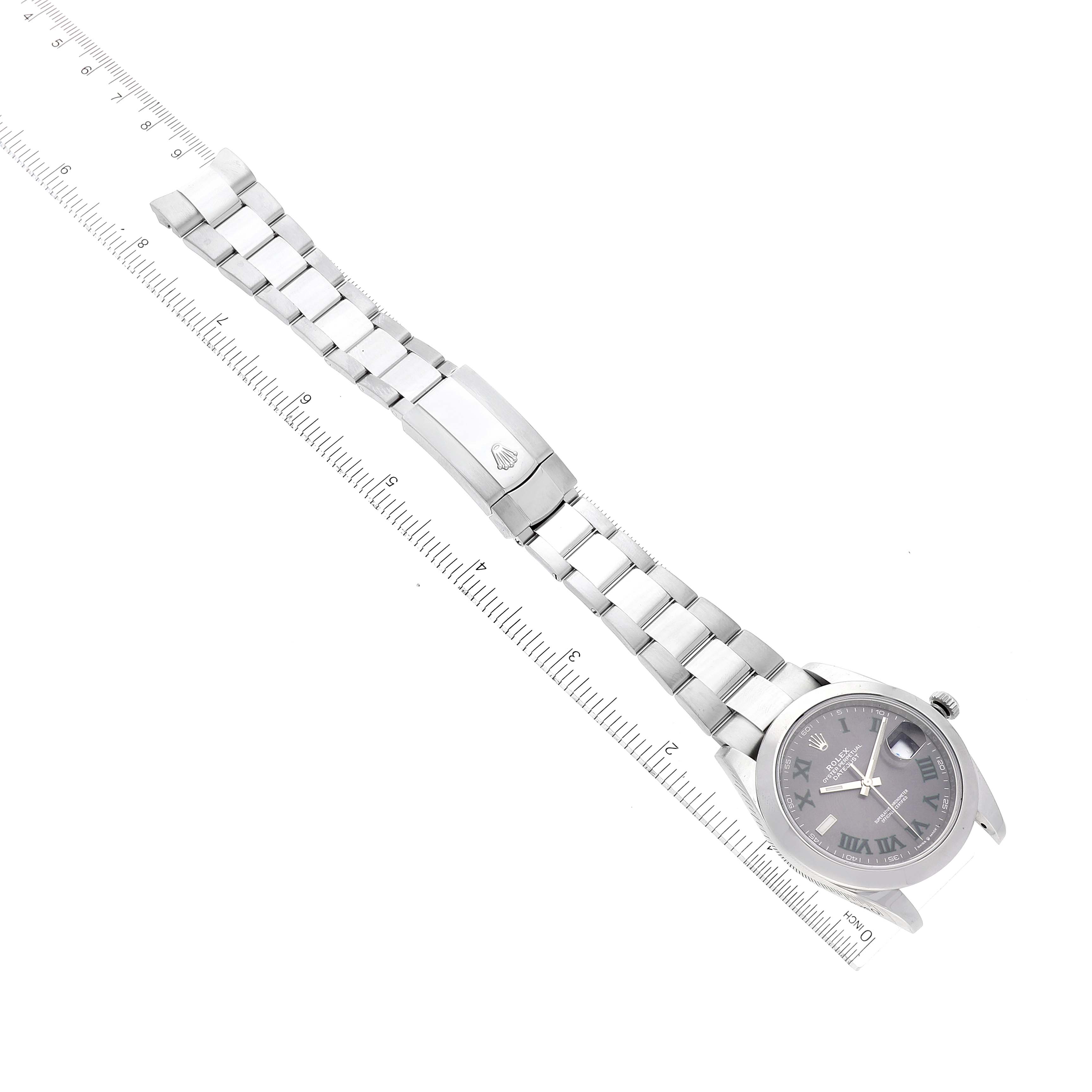 The Rolex Datejust 41 126300 Men's Stainless Steel Grey Dial 126300 Men's Stainless Steel Grey Dial watch is shown at an angled top view, highlighting the face, band and deployment clasp beside a ruler.