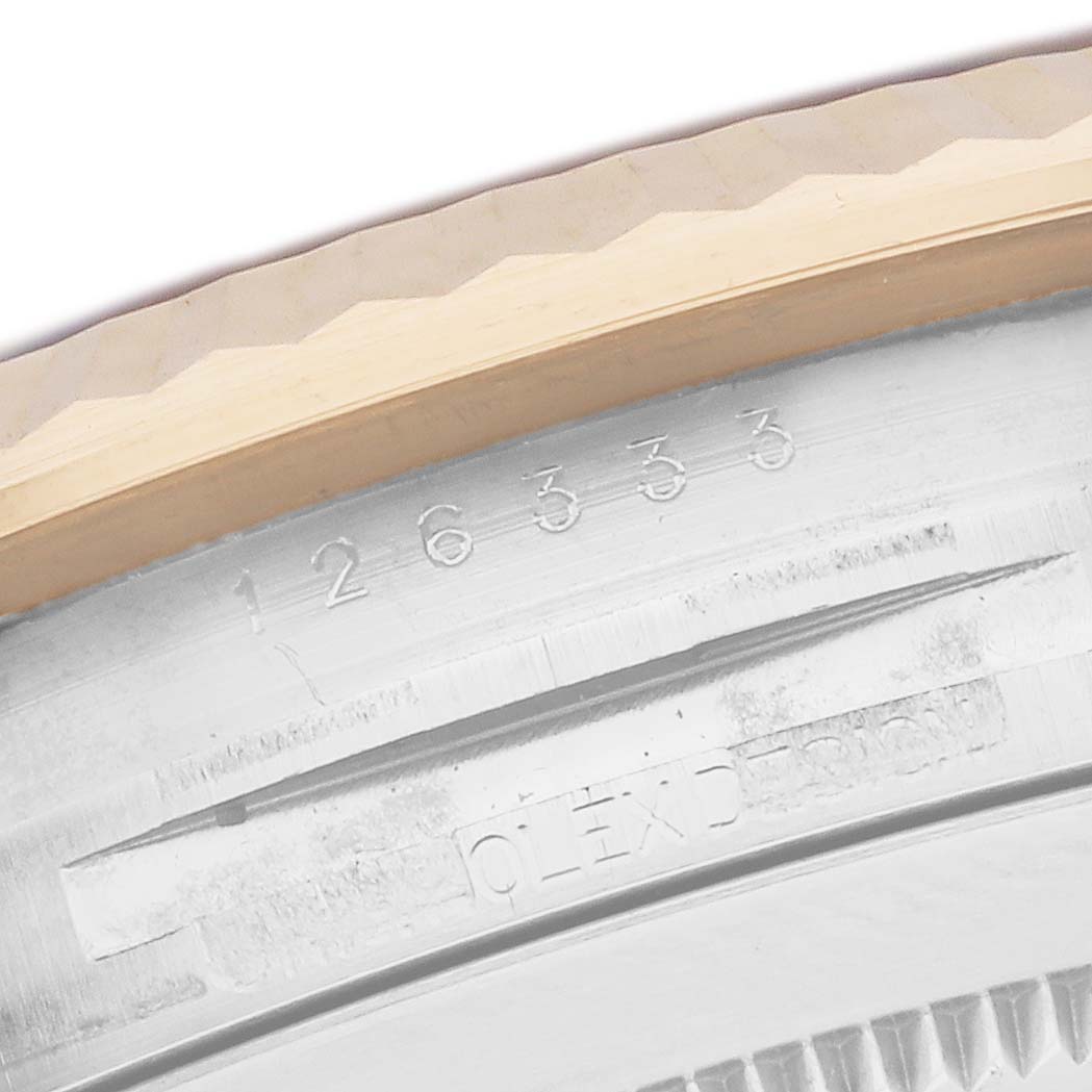 The image shows the engraved inner bezel and part of the fluted bezel of a Rolex Datejust 41 126333 Men
s Steel and Gold (two tone) Champagne Dial model.