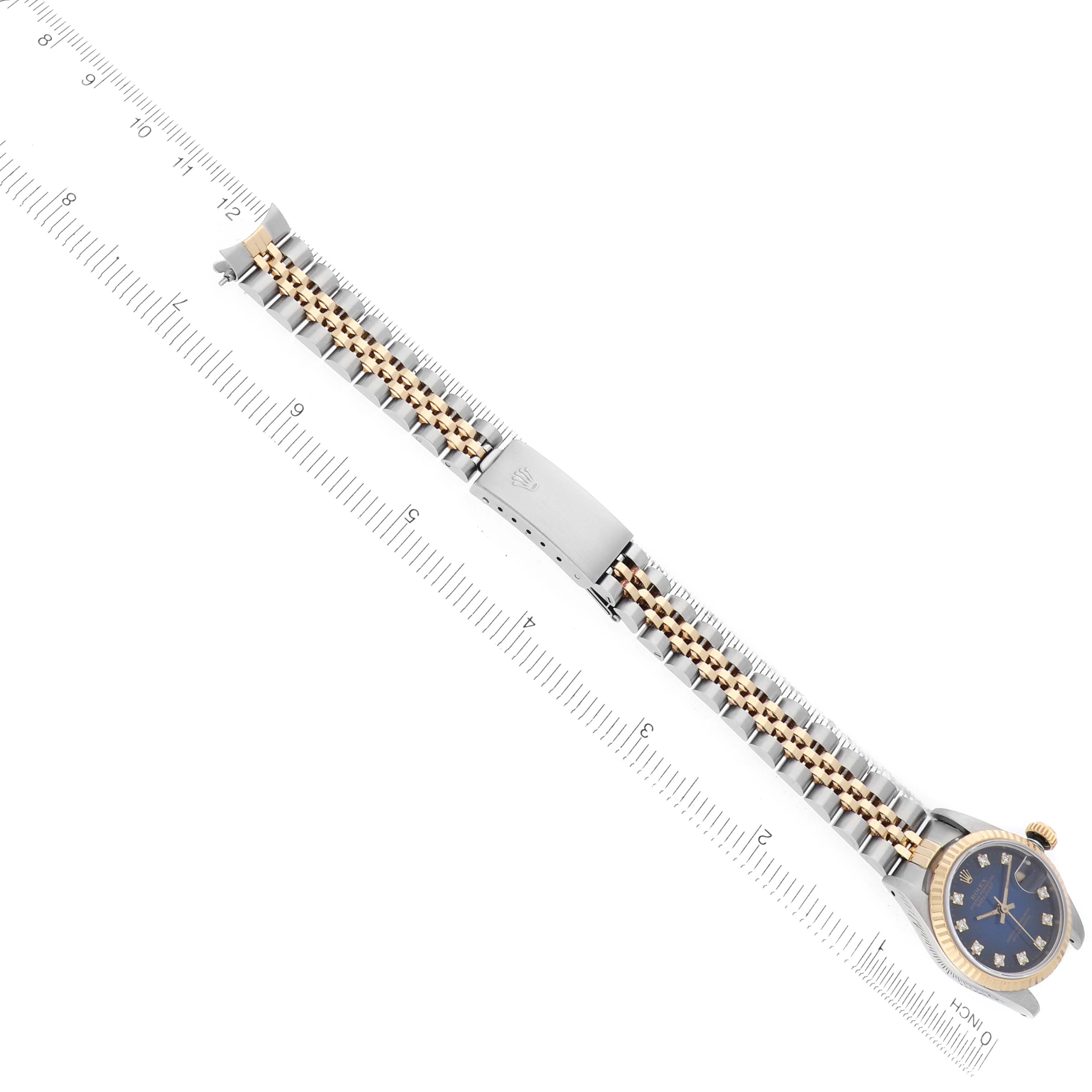 The Rolex Datejust 69173 Women
s Steel and Gold (two tone) Blue Dial watch is shown from an angled top view, displaying the face, bezel, and entire bracelet with a clasp.