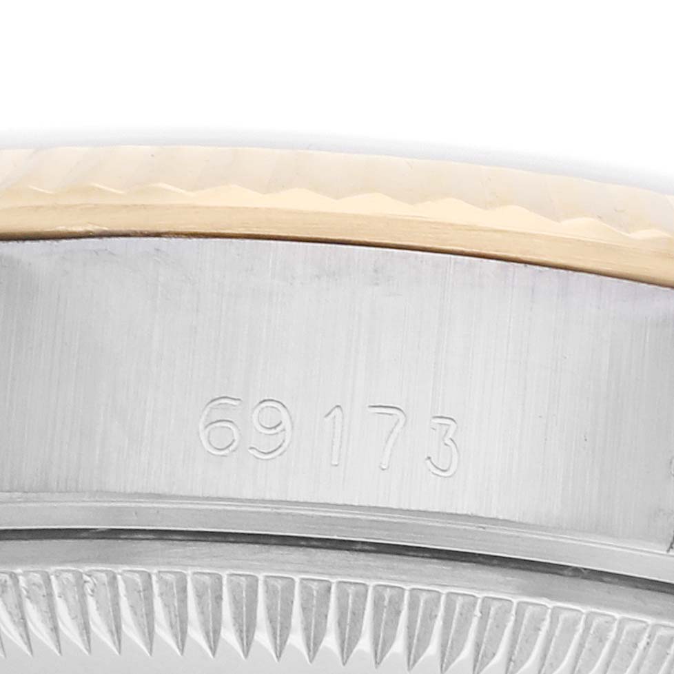 The image shows a close-up of the case side of a Rolex Datejust 69173 Women
s Steel and Gold (two tone) Blue Dial, focusing on the model number engraving.