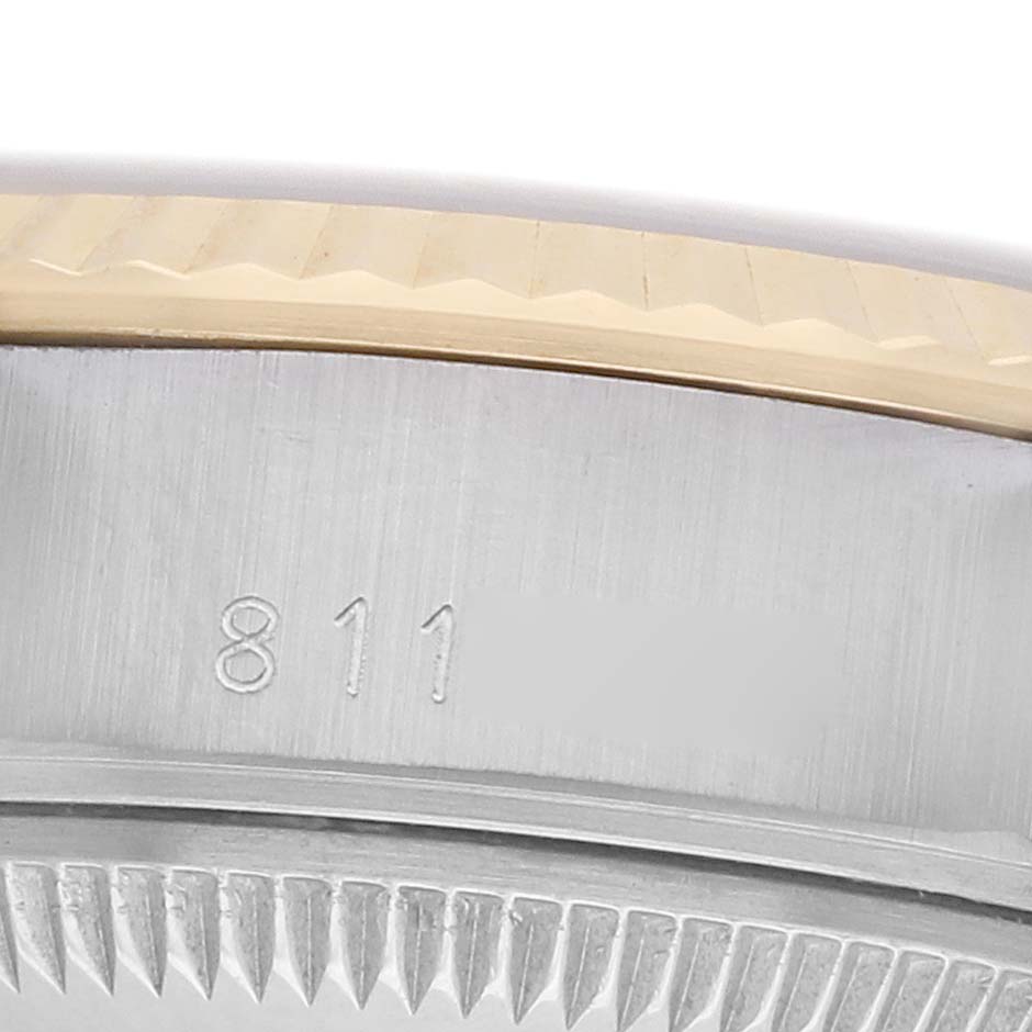 The image shows a macro view of a Rolex Datejust 69173 Women
s Steel and Gold (two tone) Blue Dial watch
s case side, focusing on part of the bezel and engraved serial number.