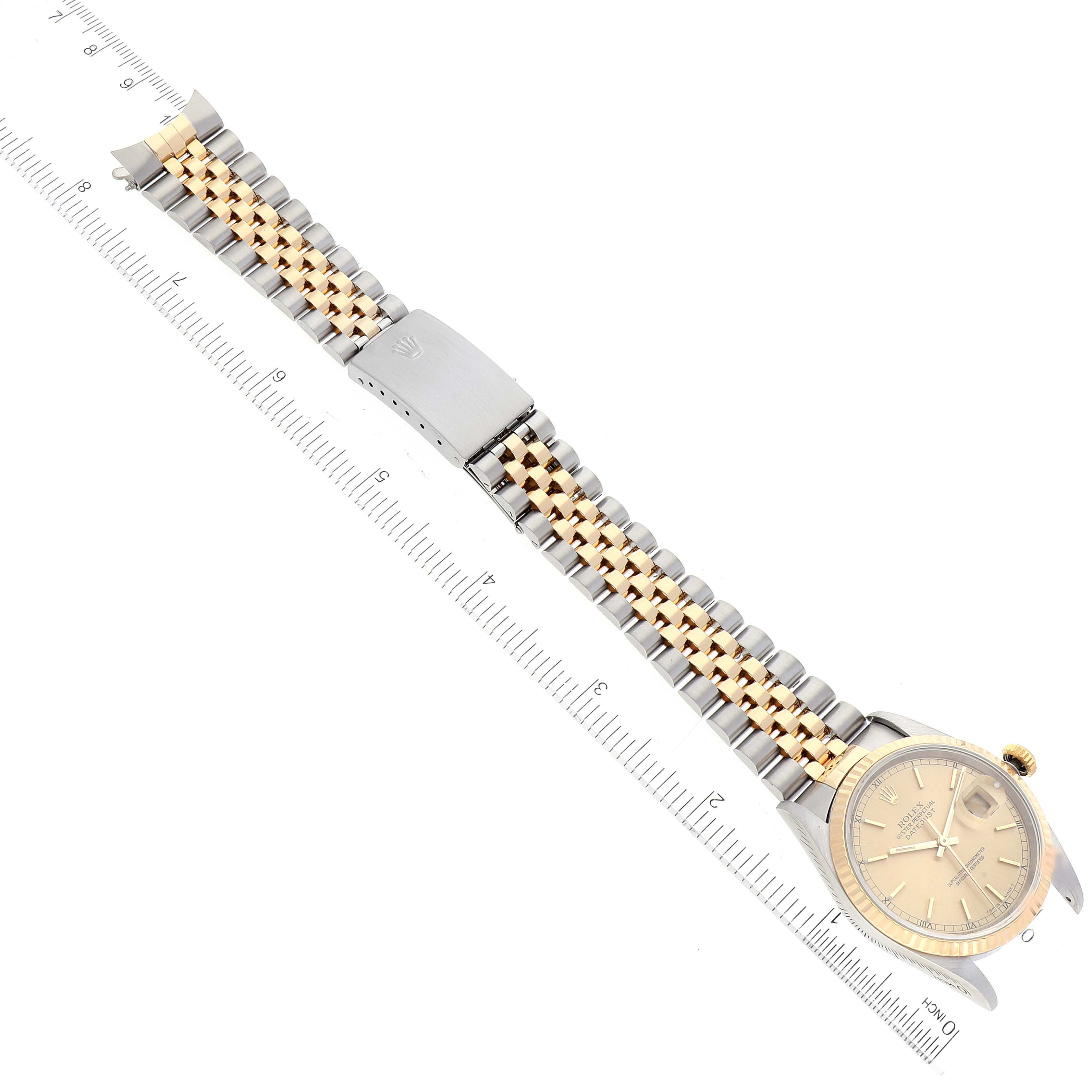 The image shows a Rolex Datejust 16233 Men's Steel and Gold (two tone) Champagne Dial 16233 Men's Steel and Gold (two tone) Champagne Dial watch with a two-tone metal bracelet, clasp, and dial, laid flat alongside a ruler.