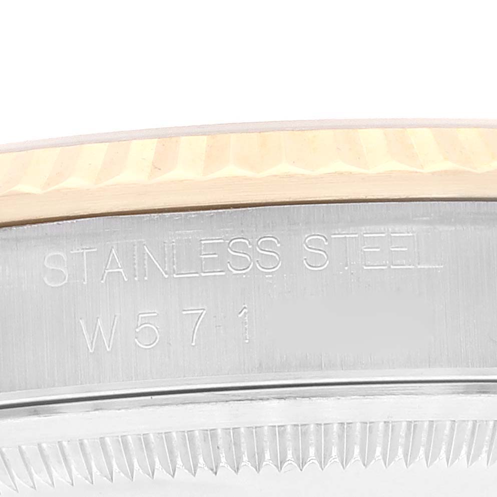 The image shows a close-up of the side of a Rolex Datejust 16233 Men's Steel and Gold (two tone) Champagne Dial 16233 Men's Steel and Gold (two tone) Champagne Dial watch, focusing on the stainless steel case with engraved text.