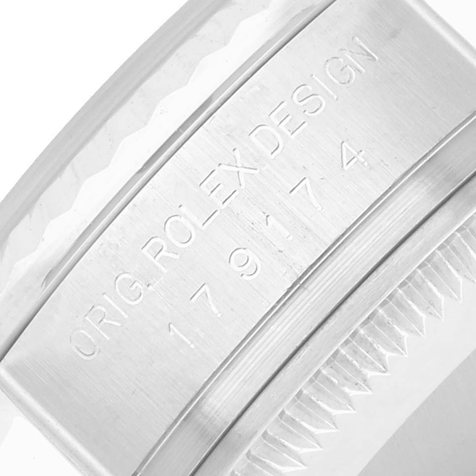 The image shows an engraved side view of a Rolex Datejust 179174 Women
s Stainless Steel White Dial watch, focusing on the detailed design and serial number.