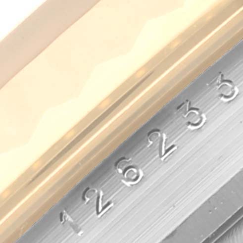 This close-up image of a Rolex Datejust 126233 Men
s Steel and Gold (two tone) Champagne Dial 126233 Men
s Steel and Gold (two tone) Champagne Dial shows the serial number engraved on the side of the watch case and part of the bezel.