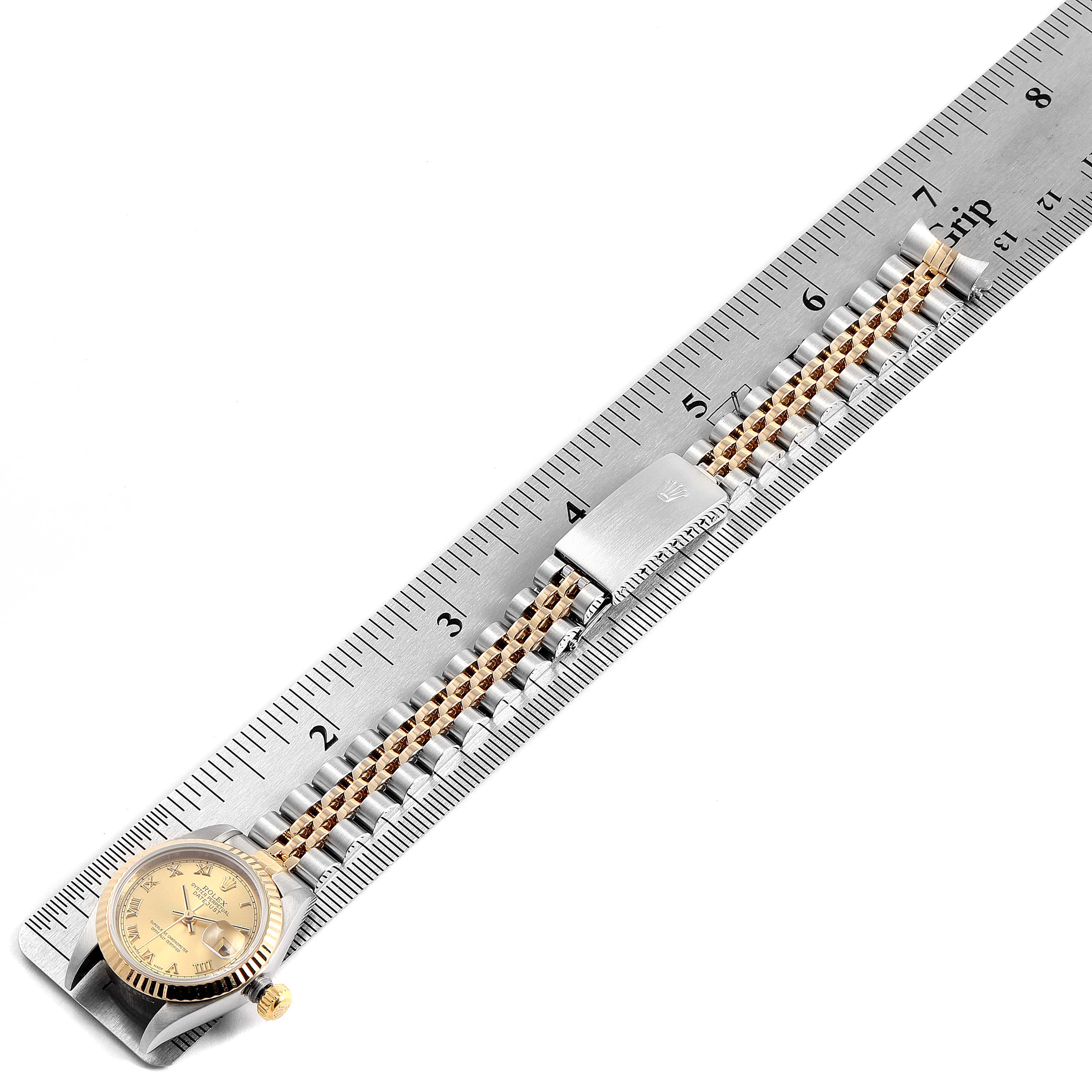 The image shows a Rolex Datejust 69173 Women's Steel and Gold (two tone) Champagne Dial 69173 Women's Steel and Gold (two tone) Champagne Dial watch placed diagonally on a ruler, highlighting the face and bracelet.