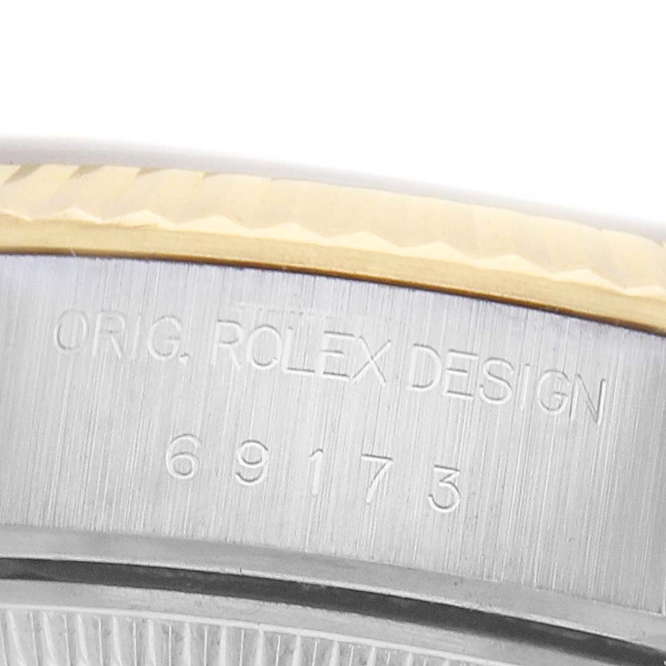 This close-up image of a Rolex Datejust 69173 Women
s Steel and Gold (two tone) Champagne Dial shows the side of the watch case with engraved model details.