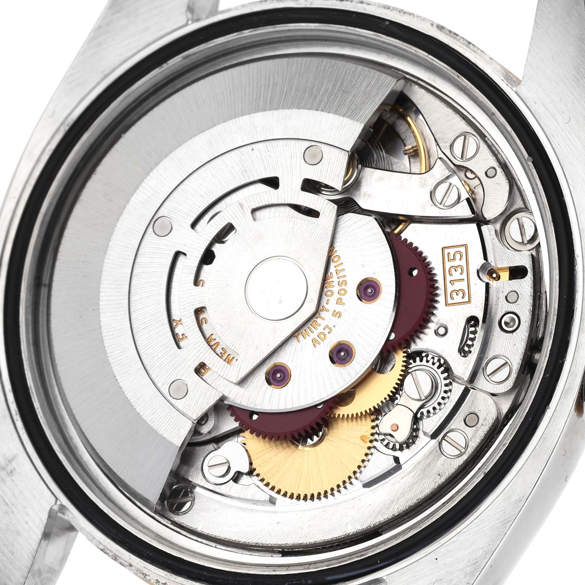 The image shows an internal view of the Rolex Datejust 116233 Men
s Steel and Gold (two tone) Champagne Dial 116233 Men
s Steel and Gold (two tone) Champagne Dial model, focusing on its intricate mechanical movement and gears.