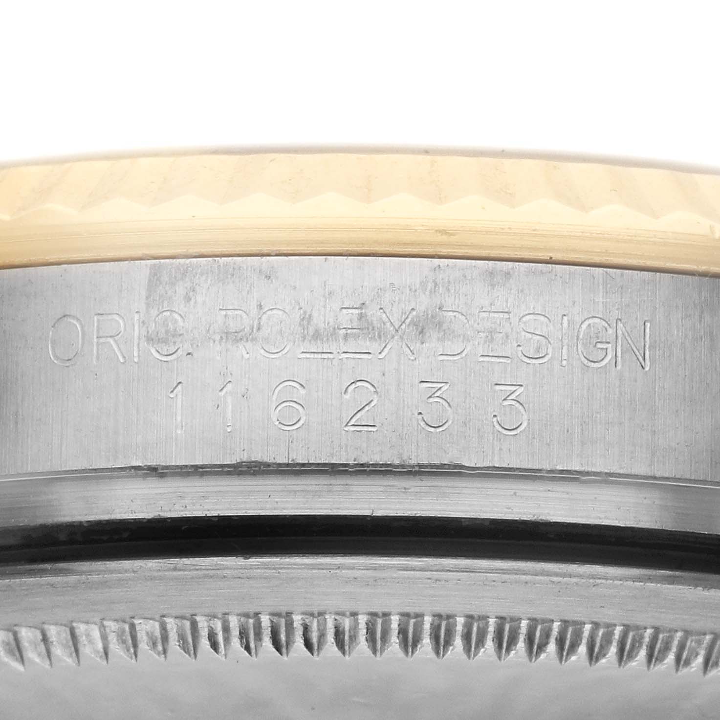 This image shows the serial number and part of the bezel on a Rolex Datejust 116233 Men
s Steel and Gold (two tone) Champagne Dial 116233 Men
s Steel and Gold (two tone) Champagne Dial watch.